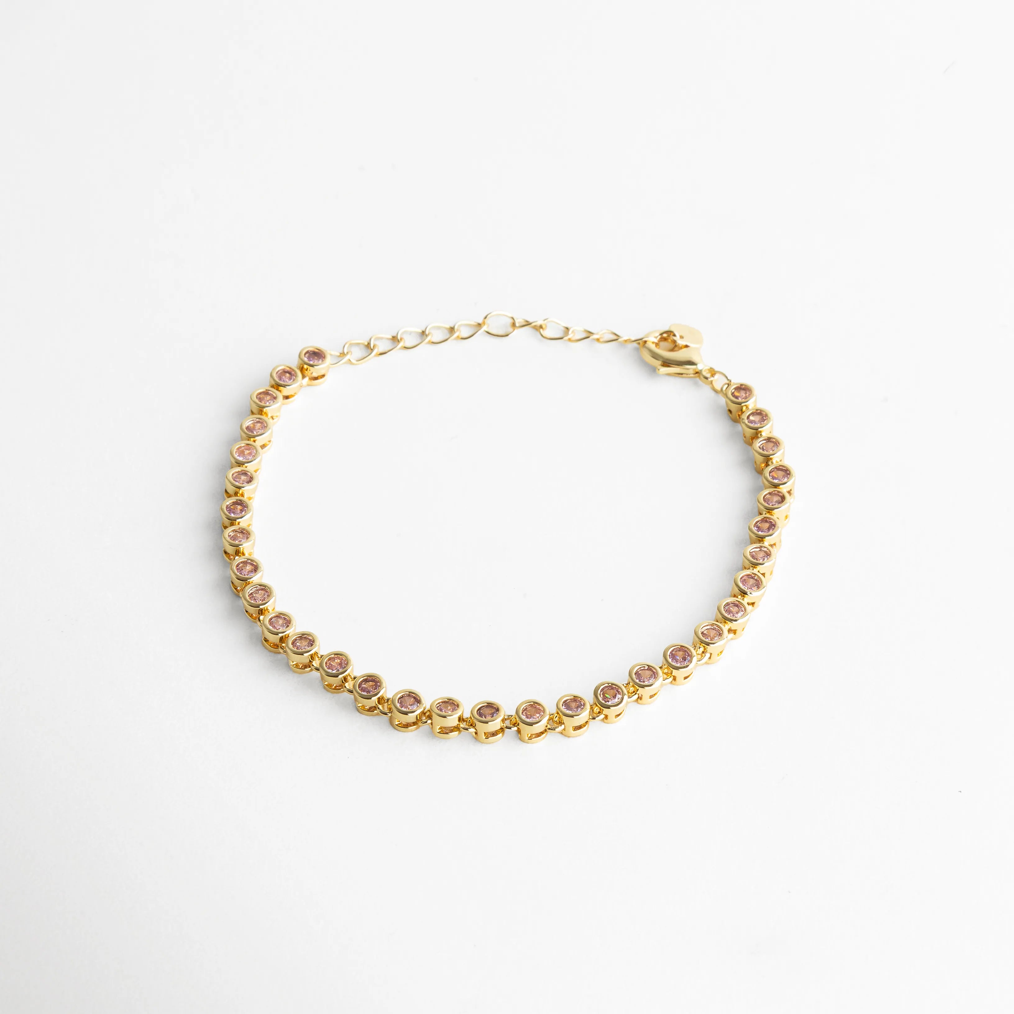 Diseño delicado con acabado dorado y piedras rosadas que reflejan la luz, ideal para un look femenino y elegante.