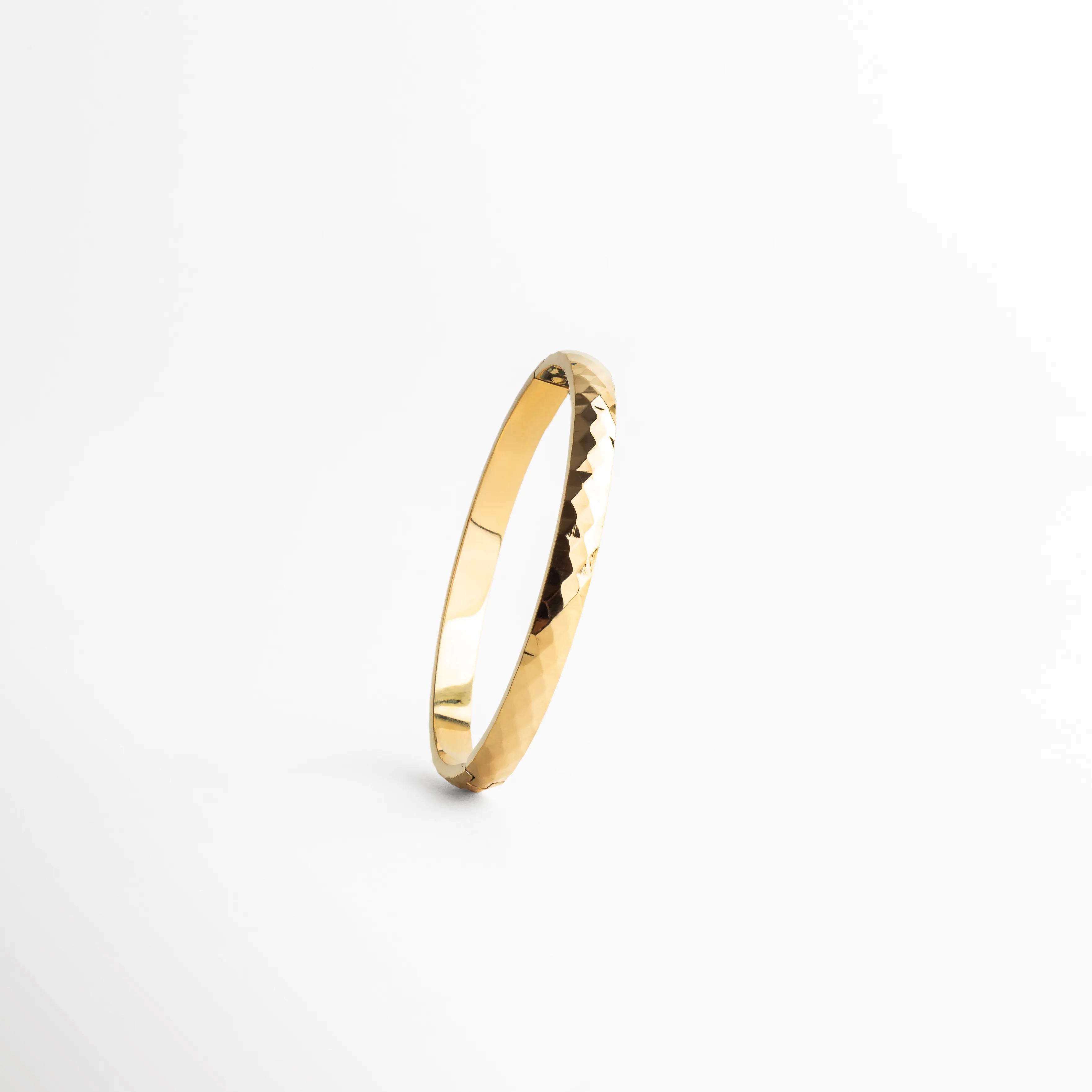 pulsera dorada vista lateral, detalle textura pulsera, joyería femenina dorada, pulsera minimal chic, accesorios elegantes mujer, pulsera contemporánea, joyería moderna