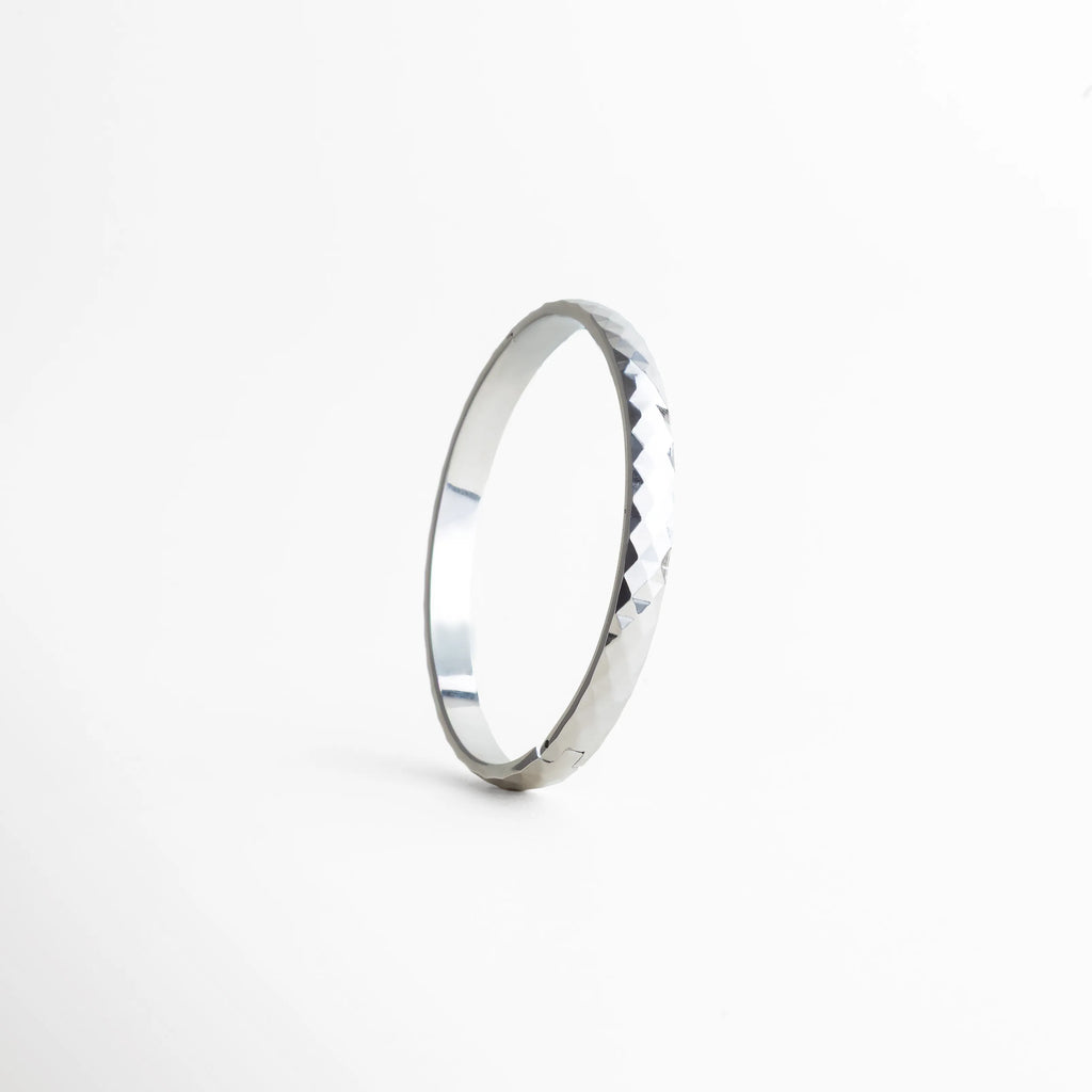 pulsera plateada vista lateral, detalle textura pulsera, joyería femenina plateada, pulsera minimal chic, accesorios elegantes mujer, pulsera contemporánea, joyería moderna