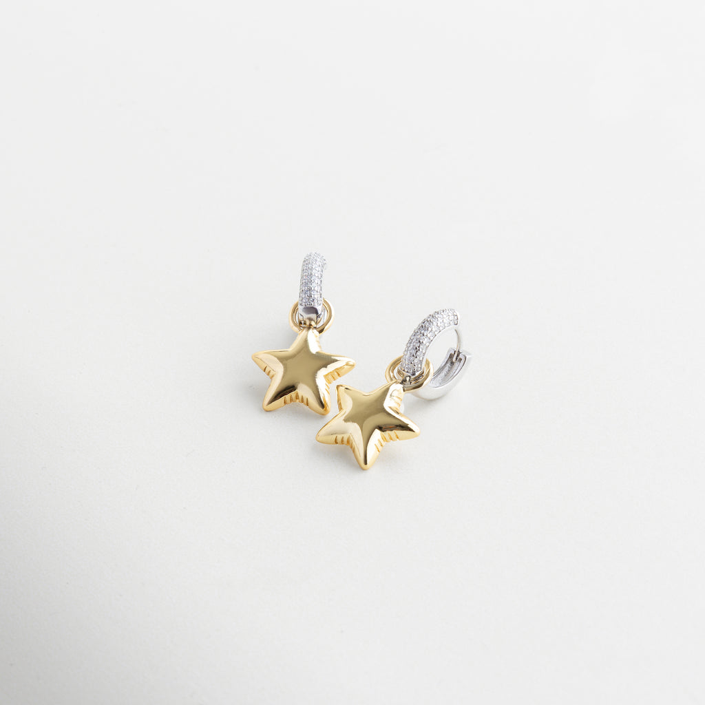 Detalle de zirconias y estrella en arete dorado, Incrustaciones brillantes en arracadas con charm, Textura y acabado de estrella colgante en dorado, Cierre y diseño del arete Frodita con cristales