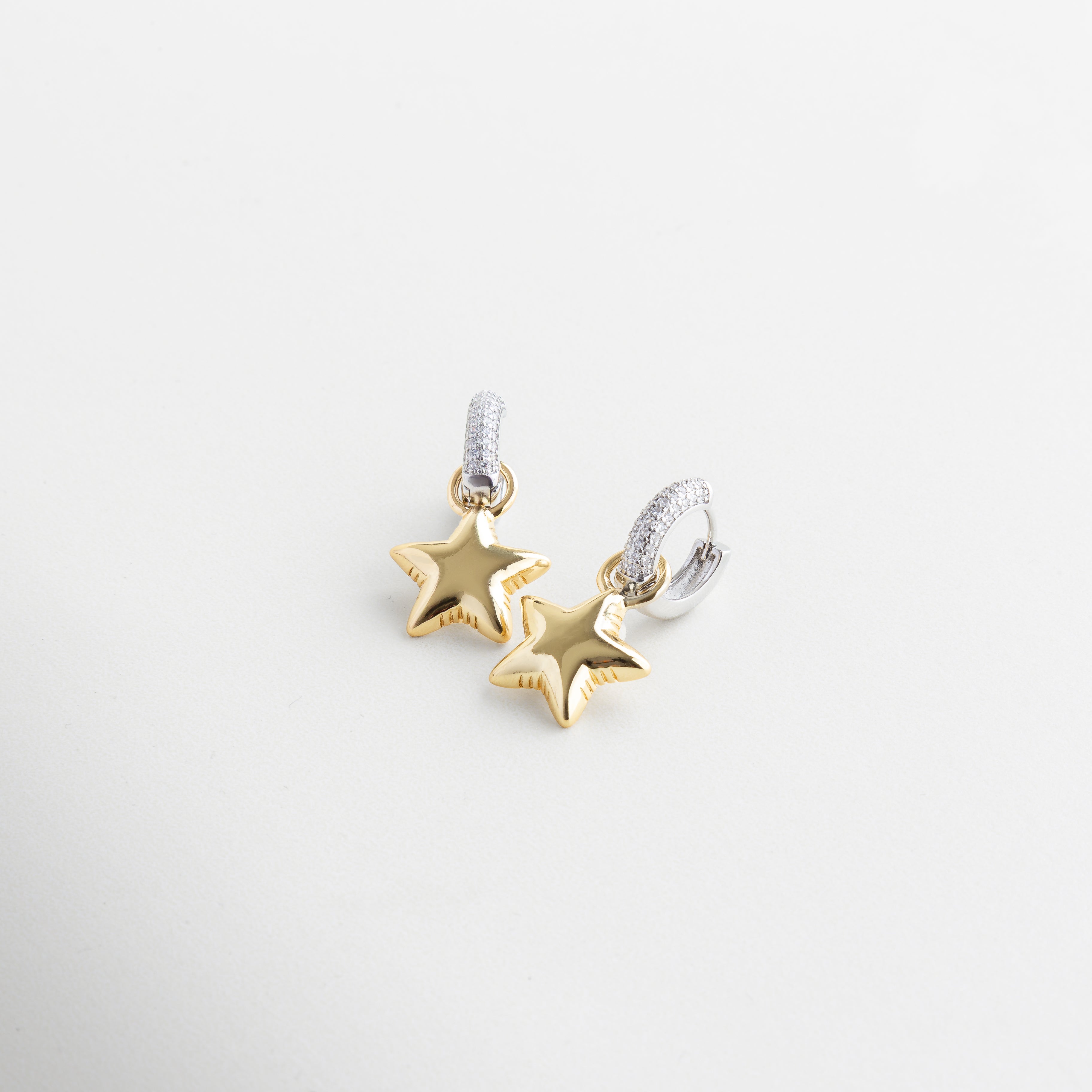 Detalle de zirconias y estrella en arete dorado, Incrustaciones brillantes en arracadas con charm, Textura y acabado de estrella colgante en dorado, Cierre y diseño del arete Frodita con cristales