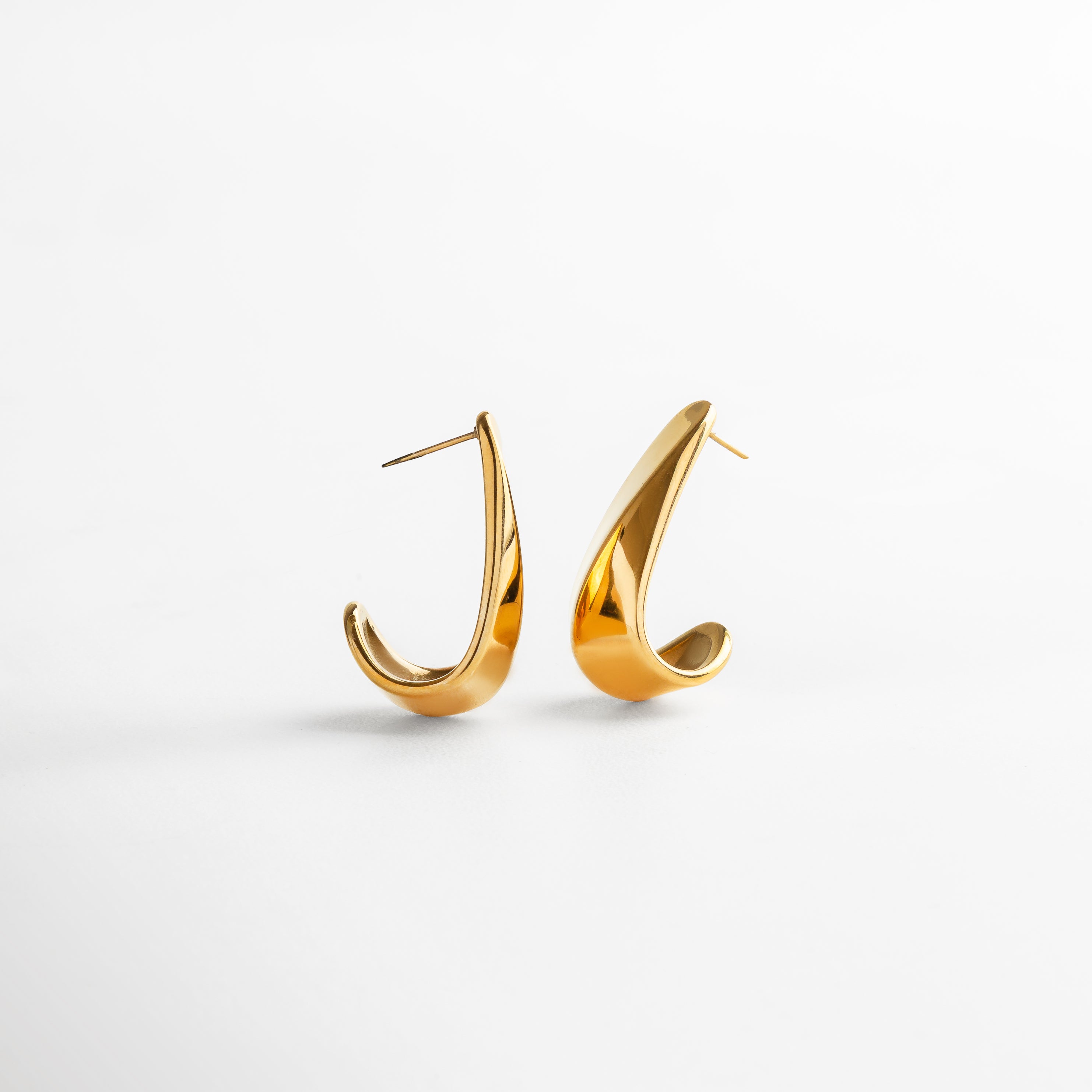 Vista superior de los Aretes Mitjana dorados, mostrando su longitud de 3.5 cm y diseño limpio. Aretes alargados en dorado vistos desde arriba, con forma recta y brillo metálico pulido. Toma cenital de los aretes dorados Mitjana, con acabado elegante y estilo versátil. Aretes con baño de oro vistos desde arriba, ideales para combinar con otros accesorios finos. Vista superior de los aretes largos dorados, con líneas suaves y proporción equilibrada.