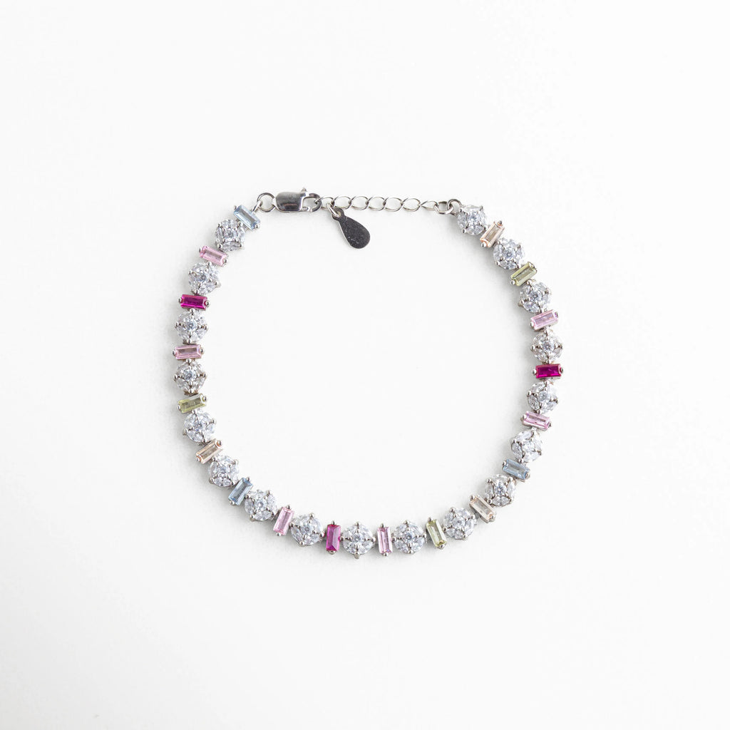 Vista cenital de pulsera circular de plata con baño de oro blanco y circonias, Brazalete completo de plata 925 con patrón infinito de piedras de colores brillantes, Pulsera tipo eternidad plateada con circonias multicolor, vista de producto completa, Accesorio de muñeca en plata de ley con acabado de lujo y piedras de colores, Composición circular de pulsera plateada con incrustaciones de cristal tipo diamante y color.