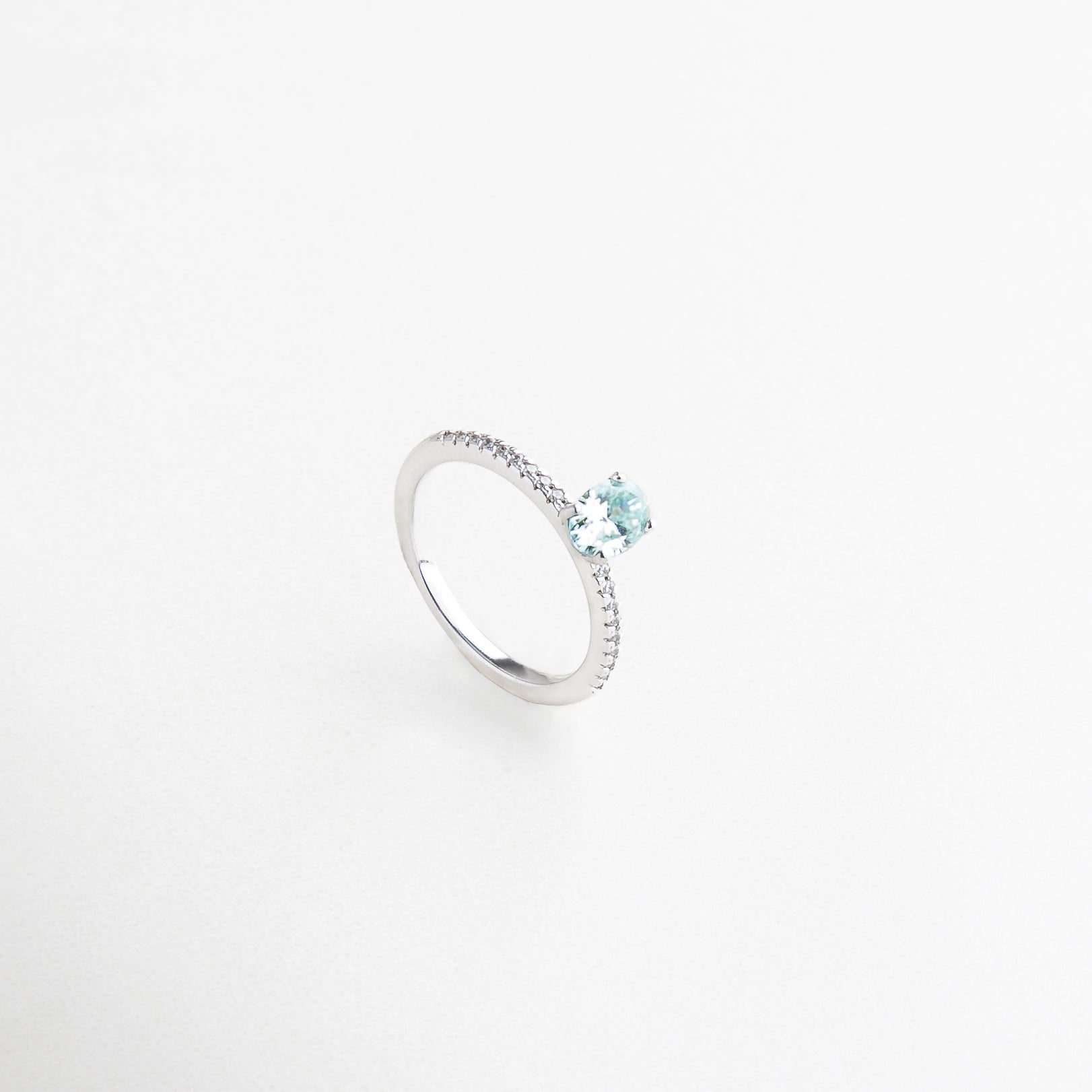 Detalle de anillo con moissanita azul clara, Moissanita ovalada celeste sobre anillo de plata, Brillo y textura de piedra celeste en plata, Acabado pulido con piedra en tono pastel