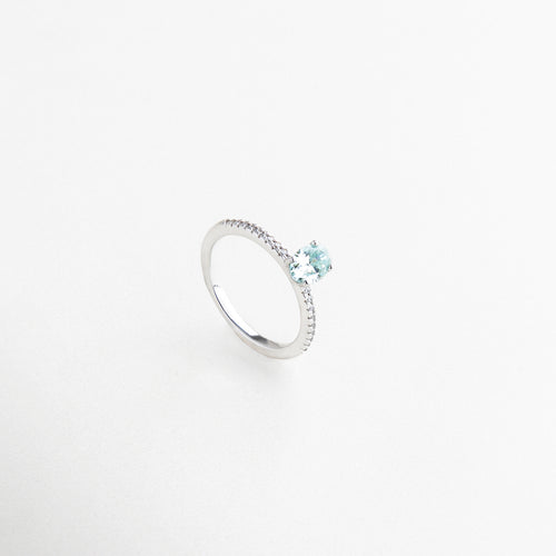 Detalle de anillo con moissanita azul clara, Moissanita ovalada celeste sobre anillo de plata, Brillo y textura de piedra celeste en plata, Acabado pulido con piedra en tono pastel