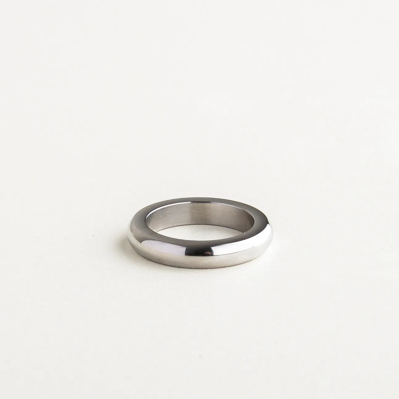 Anillo liso plateado con acabado pulido y diseño minimalista, joyería elegante y atemporal para mujer.