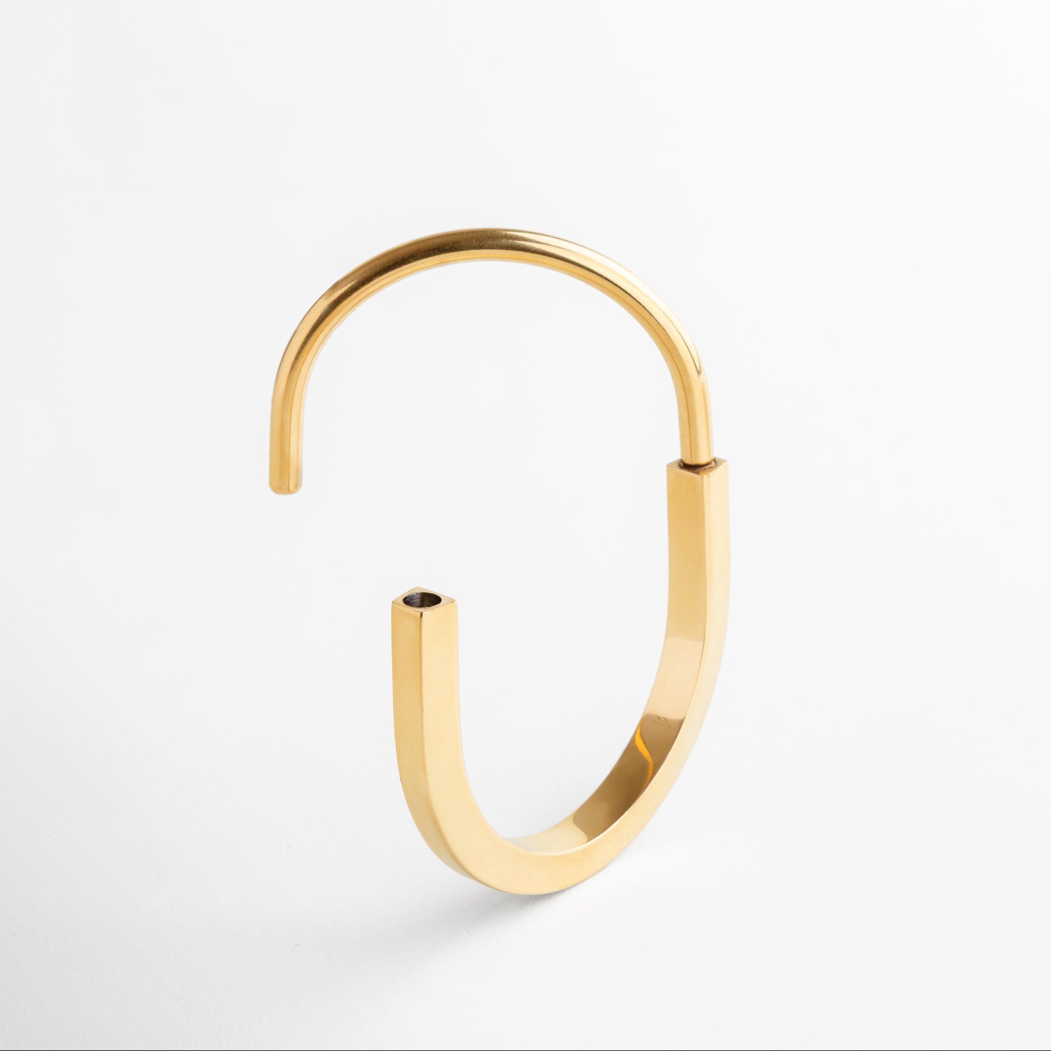 Pulsera dorada rígida tipo brazalete con acabado pulido, Diseño estructurado moderno estilo Tiffany, Pulsera statement en chapa de oro 18K con forma envolvente, Accesorio elegante y llamativo en dorado brillante