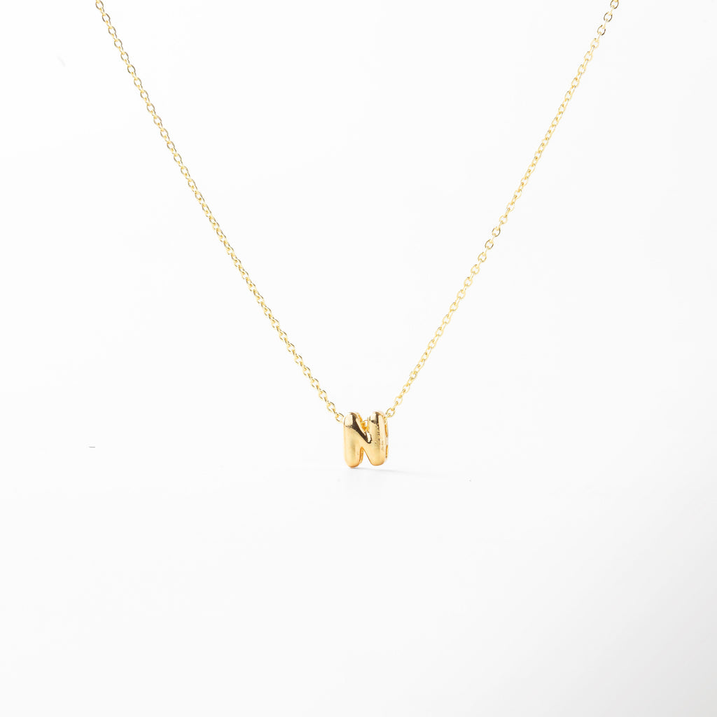 grosor del collar mini con inicial N dorada, detalle del diseño bold en la letra N del collar, cadena fina con dije de inicial N, acabado enchapado en oro 18K con letra N, collar de cobre con recubrimiento dorado