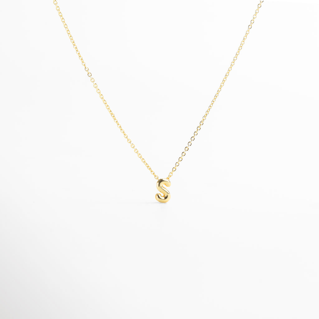 grosor del collar mini con inicial S dorada, detalle del diseño bold en la letra S del collar, cadena fina con dije de inicial S, acabado enchapado en oro 18K con letra S, collar de cobre con recubrimiento dorado