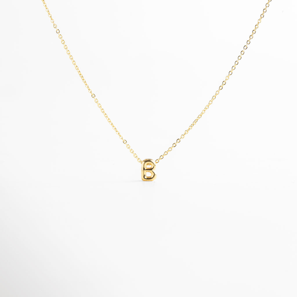 grosor del collar mini con inicial B dorada, detalle del diseño bold en la letra B del collar, cadena fina con dije de inicial B, acabado enchapado en oro 18K con letra B, collar de cobre con recubrimiento dorado