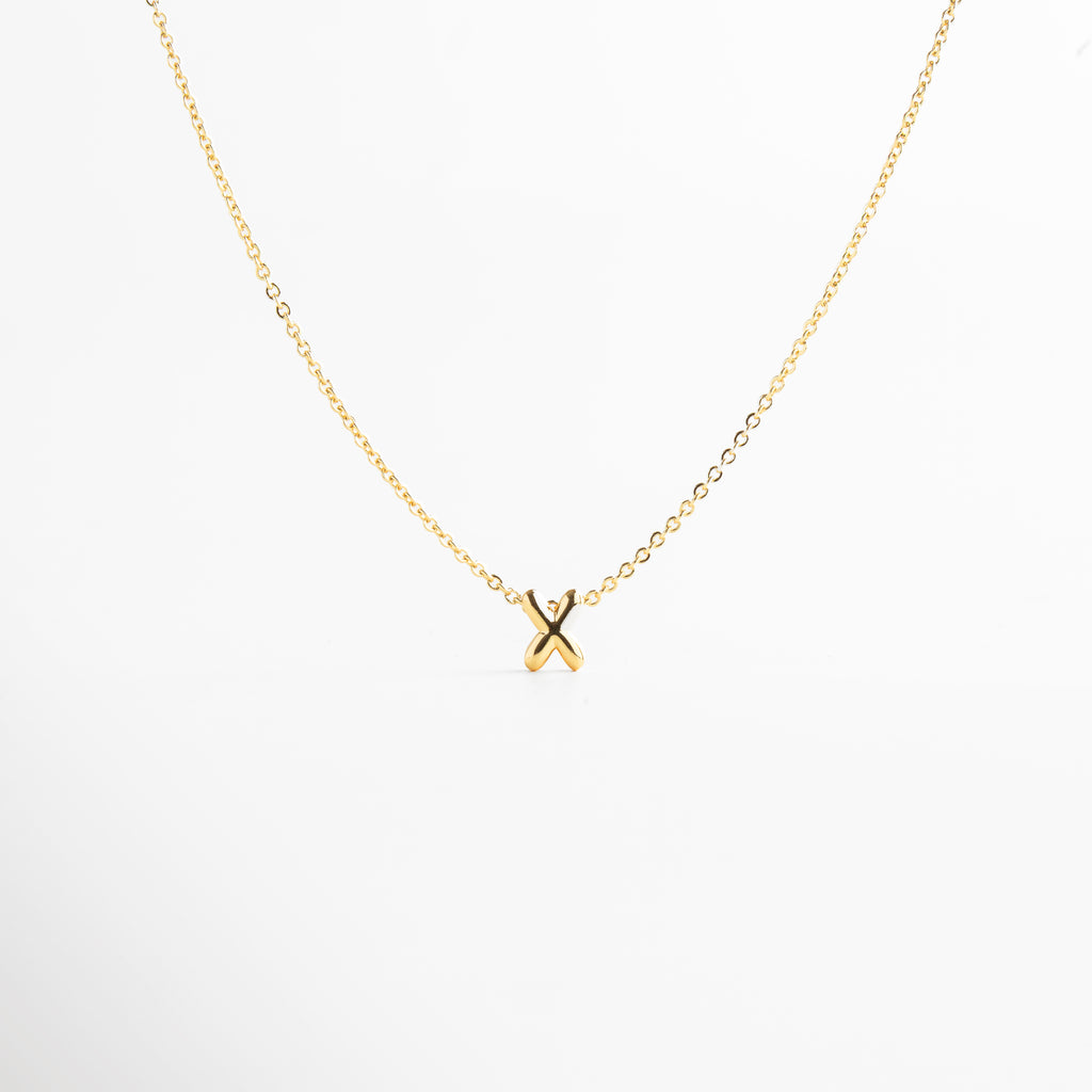 grosor del collar mini con inicial X dorada, detalle del diseño bold en la letra X del collar, cadena fina con dije de inicial X, acabado enchapado en oro 18K con letra X, collar de cobre con recubrimiento dorado