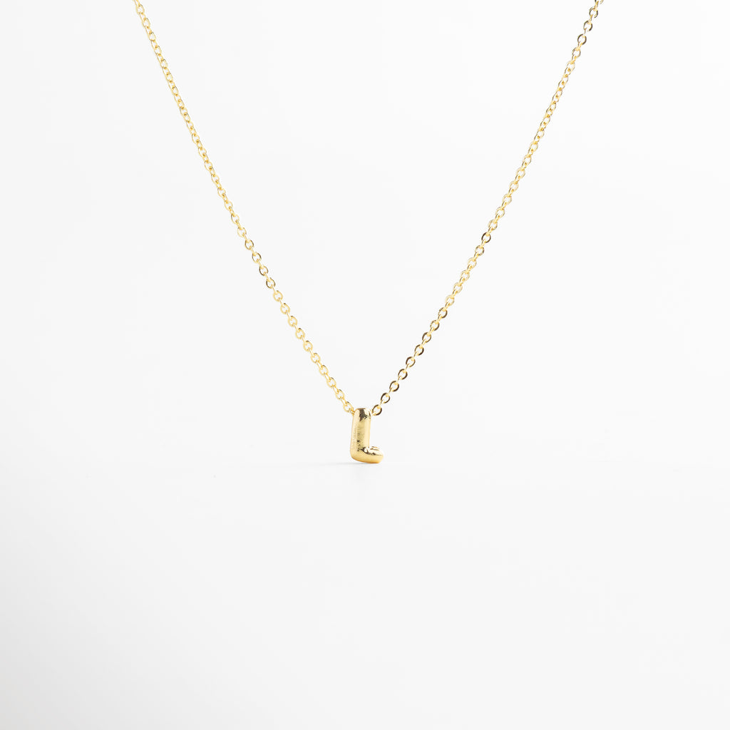 grosor del collar mini con inicial L dorada, detalle del diseño bold en la letra L del collar, cadena fina con dije de inicial L, acabado enchapado en oro 18K con letra L, collar de cobre con recubrimiento dorado
