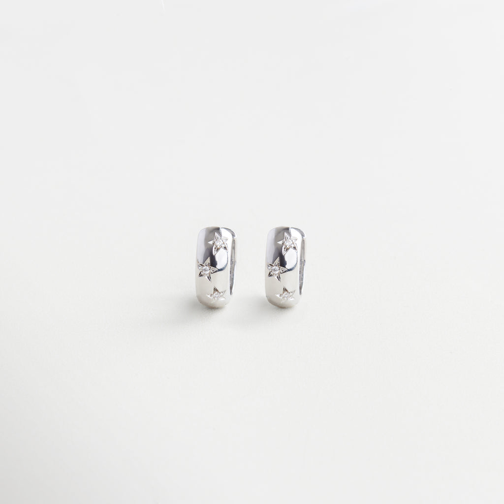 Arracadas plateadas con estrellas y zirconias, Aretes de aro con diseño celestial, Hoops con acabado en oro blanco 18K, Aretes pequeños estilo constelación plateada, Par de aros con estrellas brillantes