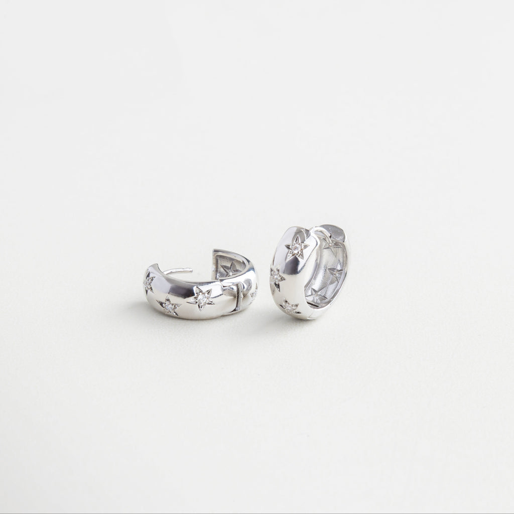 Cierre tipo broche discreto en aro plateado, Mecanismo de clip oculto y seguro, Detalle de broche integrado al diseño, Sistema de cierre funcional y estético, Cierre metálico con acabado en oro blanco