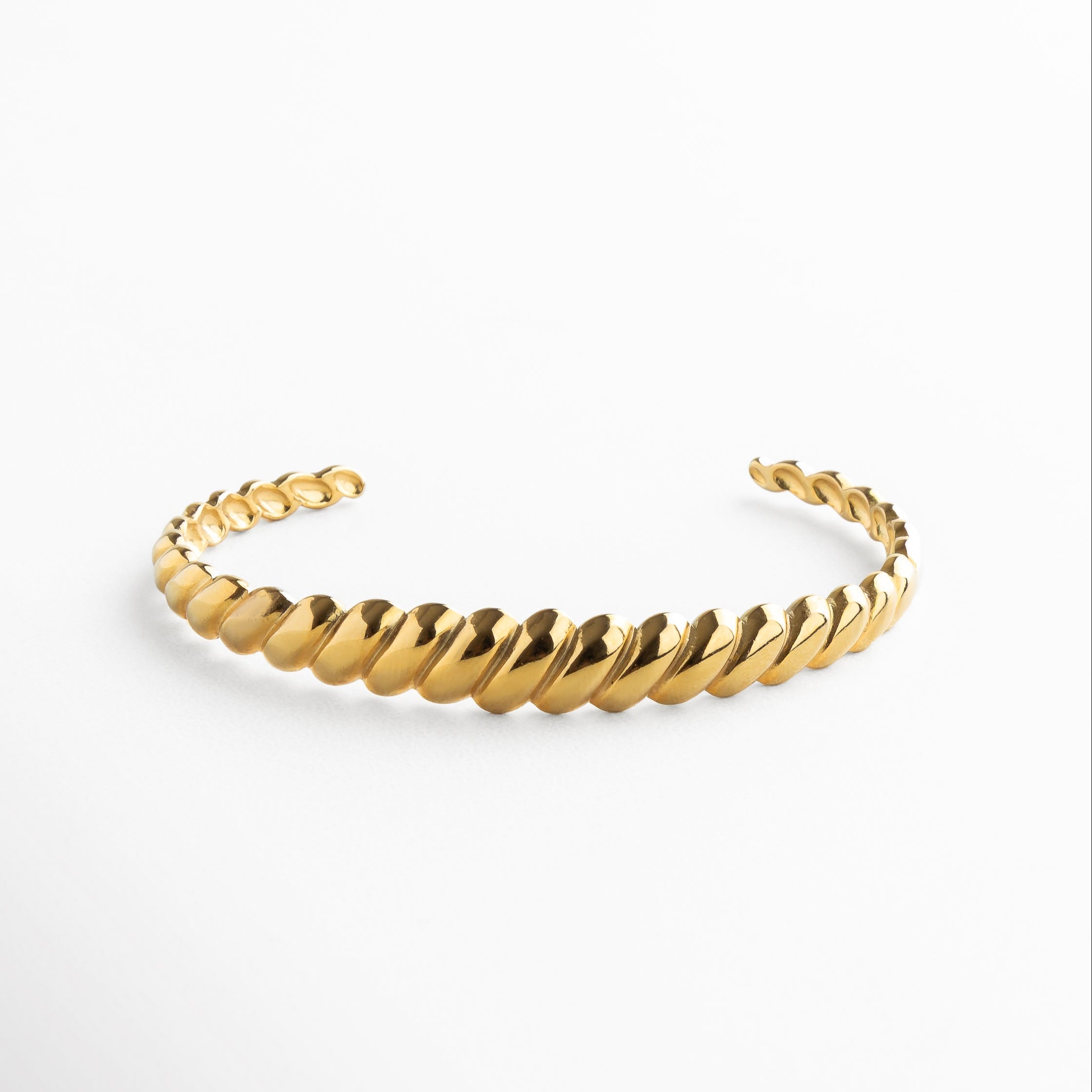 Pulsera rígida dorada con textura de líneas diagonales, Brazalete dorado de acero inoxidable con diseño geométrico, Pulsera dorada tipo cuff con patrón grabado en diagonal, Joya dorada minimalista con acabado texturizado
