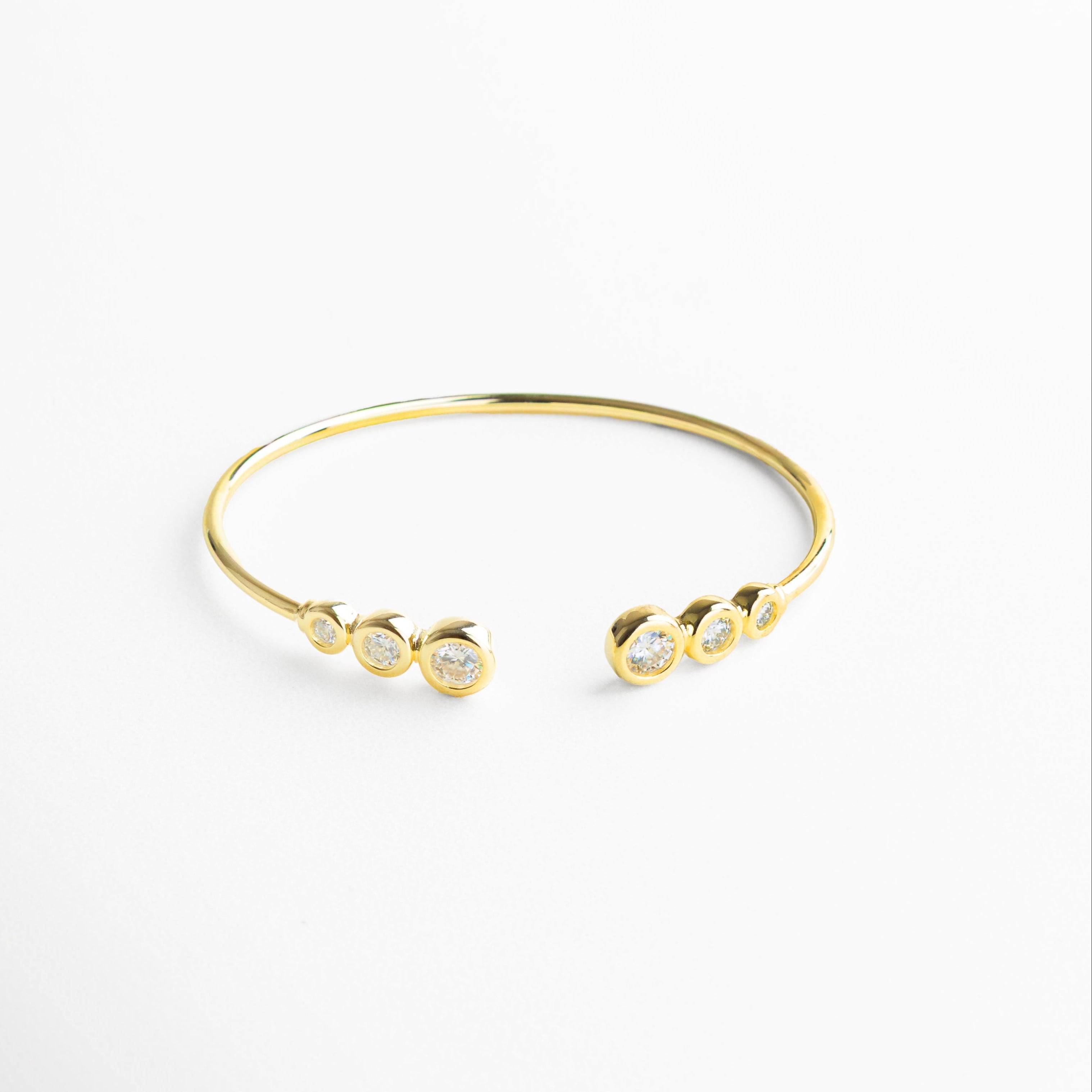 Joya de diseño minimalista con líneas limpias y elegantes, Plata esterlina con baño en chapa de oro 18K que aporta un brillo sutil y sofisticado, Incrustaciones de moissanita que reflejan luz con intensidad y delicadeza, Estilo contemporáneo europeo que combina simplicidad y lujo natural, Perfecta para complementar cualquier outfit con un toque de elegancia discreta