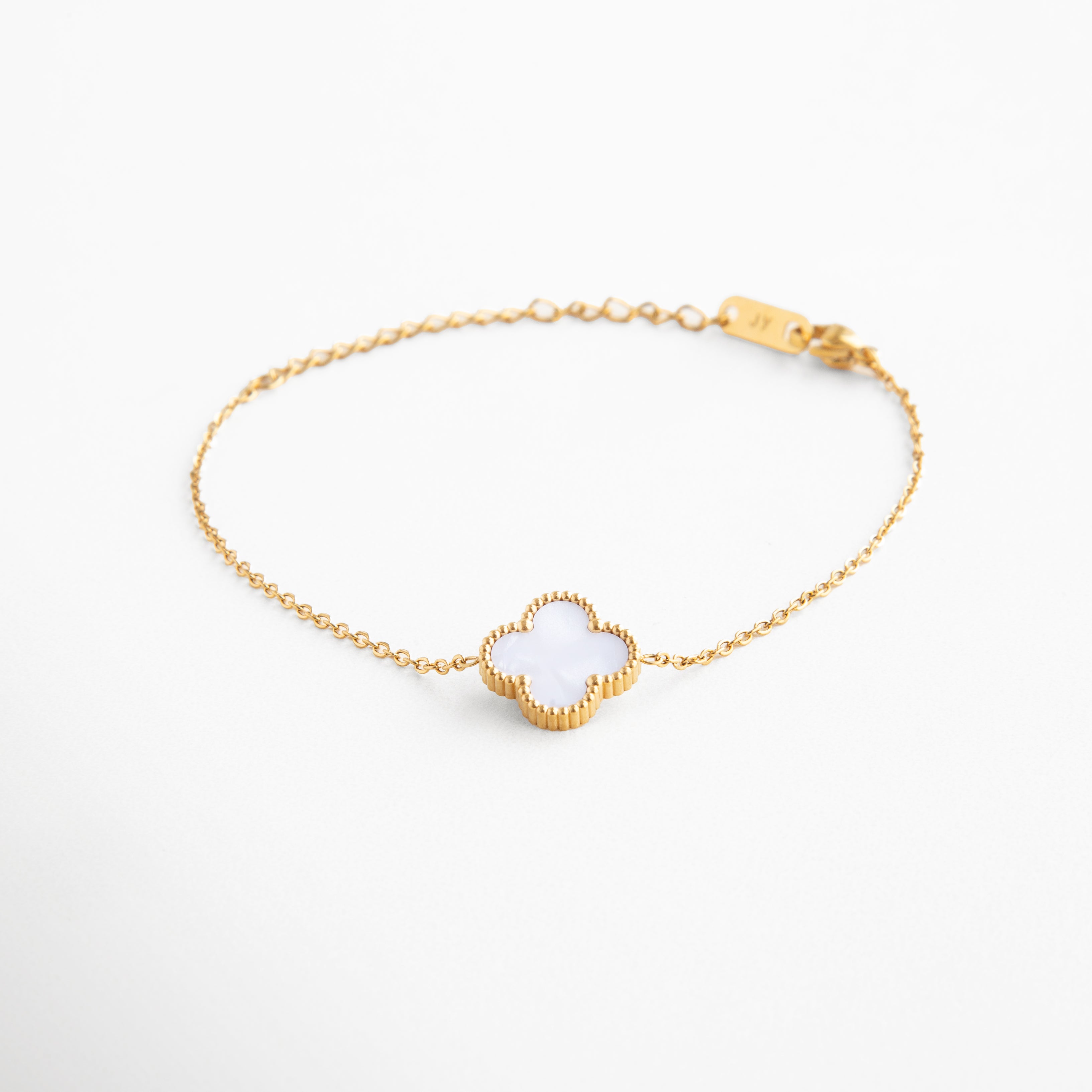 Pulsera dorada con dije de trébol blanco y piedra nácar, Joya de acero inoxidable con baño de oro 18K, Pulsera elegante con diseño de buena suerte, Accesorio minimalista con símbolo de fortuna, Diseño armonioso con encanto natural y sutil