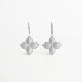 Aretes florales plateados con zirconias brillantes, Par de aretes en forma de flor con acabado plateado, Aretes plateados con diseño tridimensional y brillo sutil, Aretes flor escultural en tono plateado con zirconias