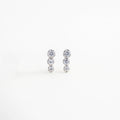 Aretes pequeños plateados con tres esferas de zirconia, Par de aretes minimalistas plateados con destello sutil, Aretes Tris plateados con zirconias brillantes, Joyería discreta y elegante: aretes plateados con tres piedras