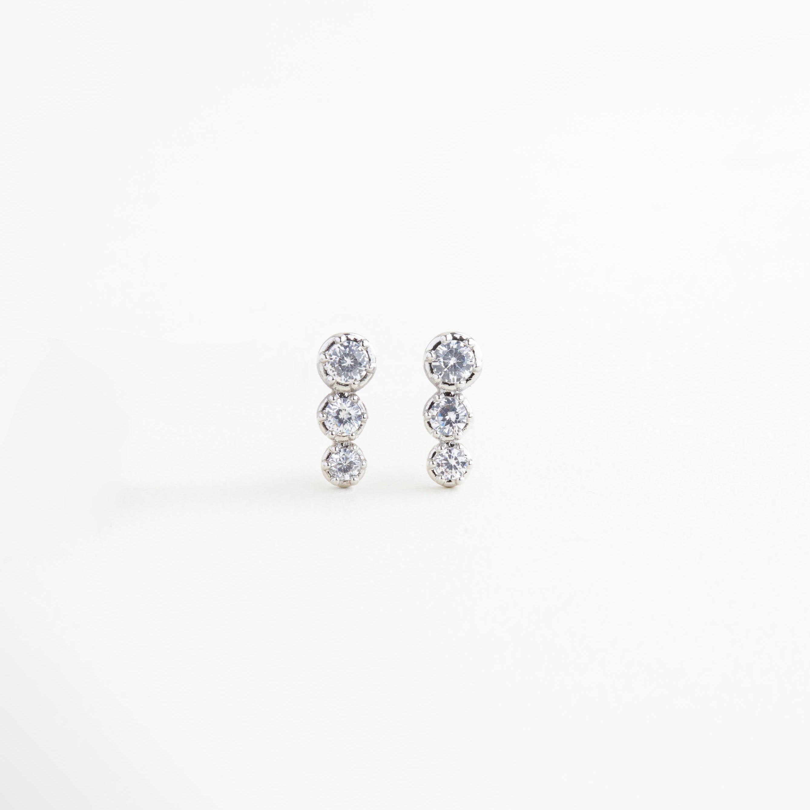 Aretes pequeños plateados con tres esferas de zirconia, Par de aretes minimalistas plateados con destello sutil, Aretes Tris plateados con zirconias brillantes, Joyería discreta y elegante: aretes plateados con tres piedras