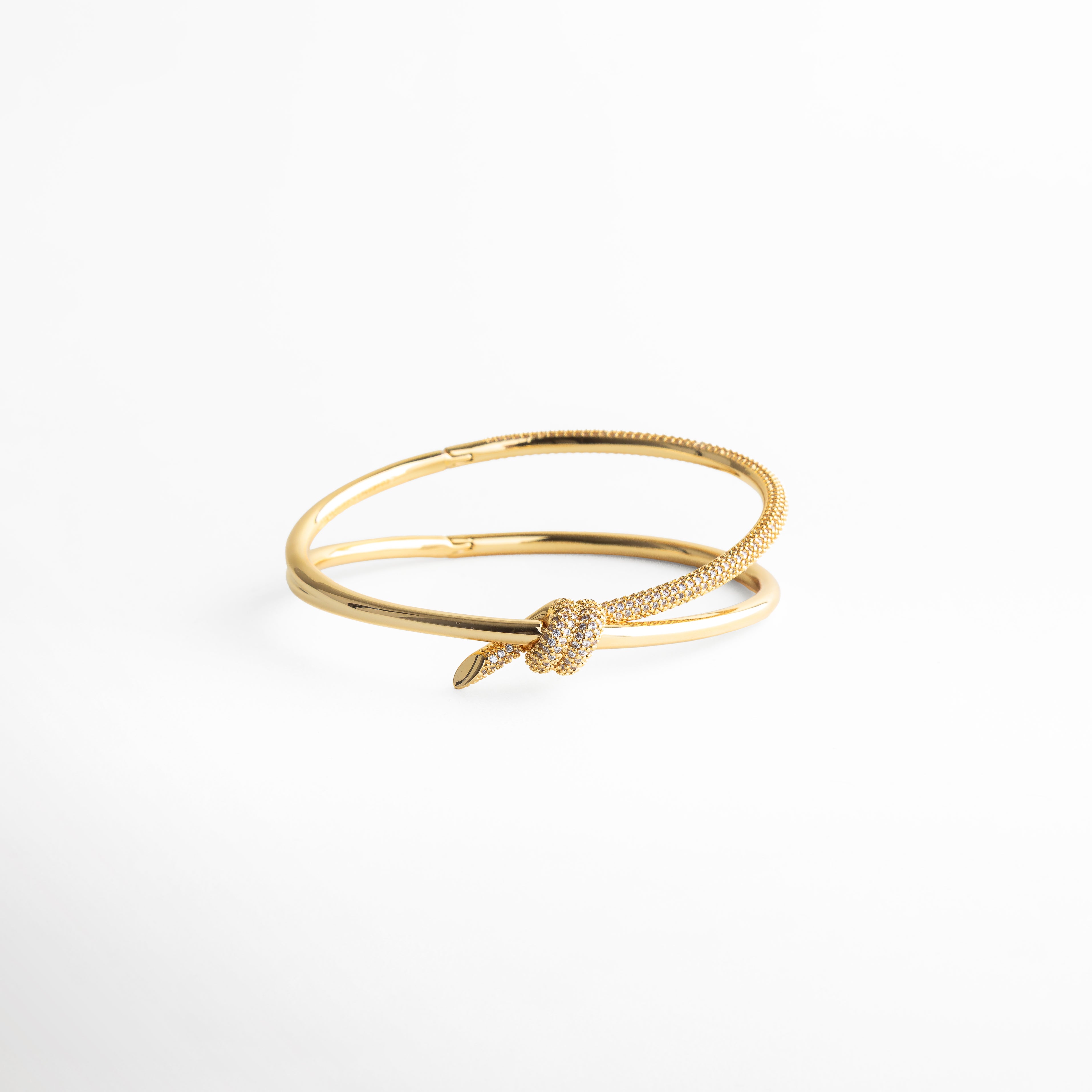 pulsera dorada con nudo, pulsera fina elegante, joyería dorada minimal, pulsera simbólica mujer, accesorios dorados sofisticados, pulsera delicada, joyería atemporal, pulsera elegante diaria