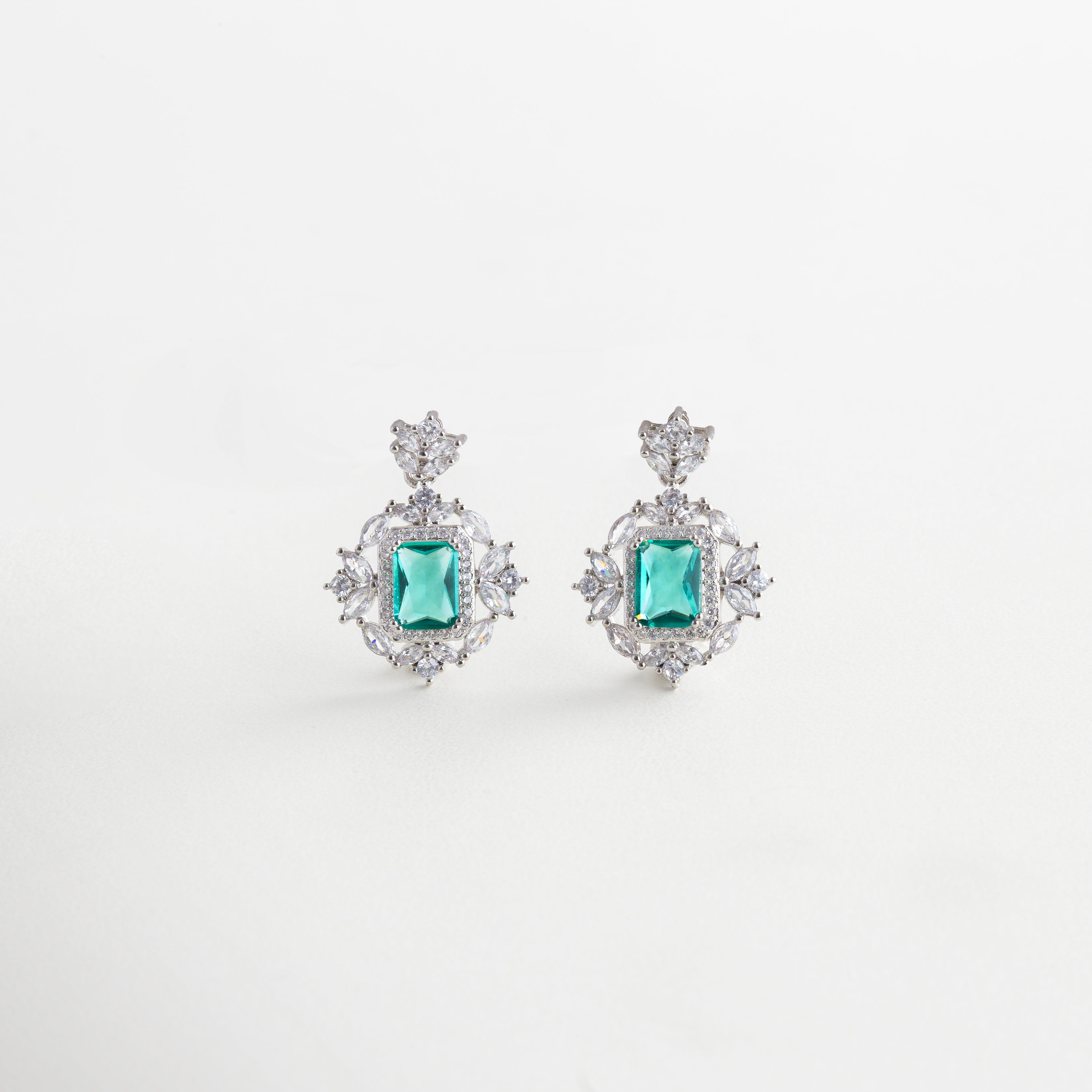 Aretes pequeños con piedra verde y halo de zirconias, Par de aretes con centro verde intenso y borde brillante, Aretes Sami Mint con zirconias y piedra de corte esmeralda, Aretes elegantes con piedra central verde y pétalos luminosos