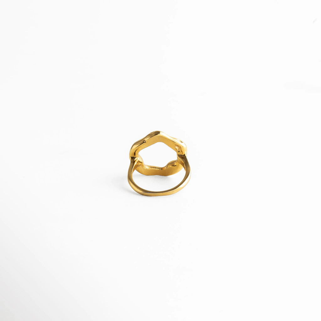 Anillo con estructura abierta y forma ondulada, aportando un toque contemporáneo y sofisticado.