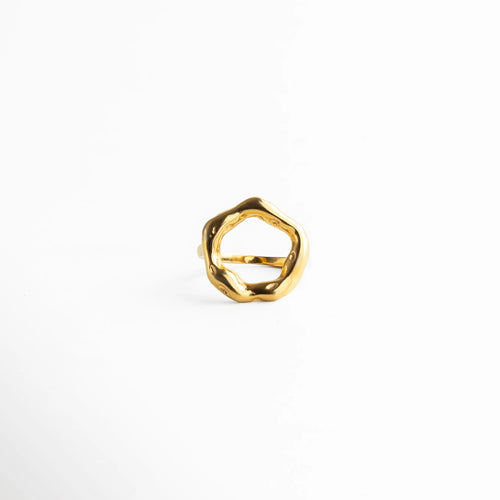 Anillo dorado con diseño circular irregular y acabado pulido, una pieza moderna con inspiración escultórica.