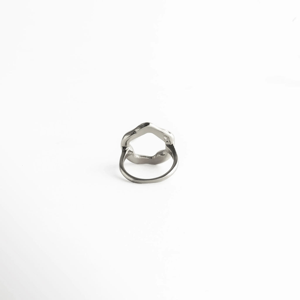 Diseño abierto en la parte superior con acabado metálico pulido, ideal para complementar looks sofisticados con un toque artístico.