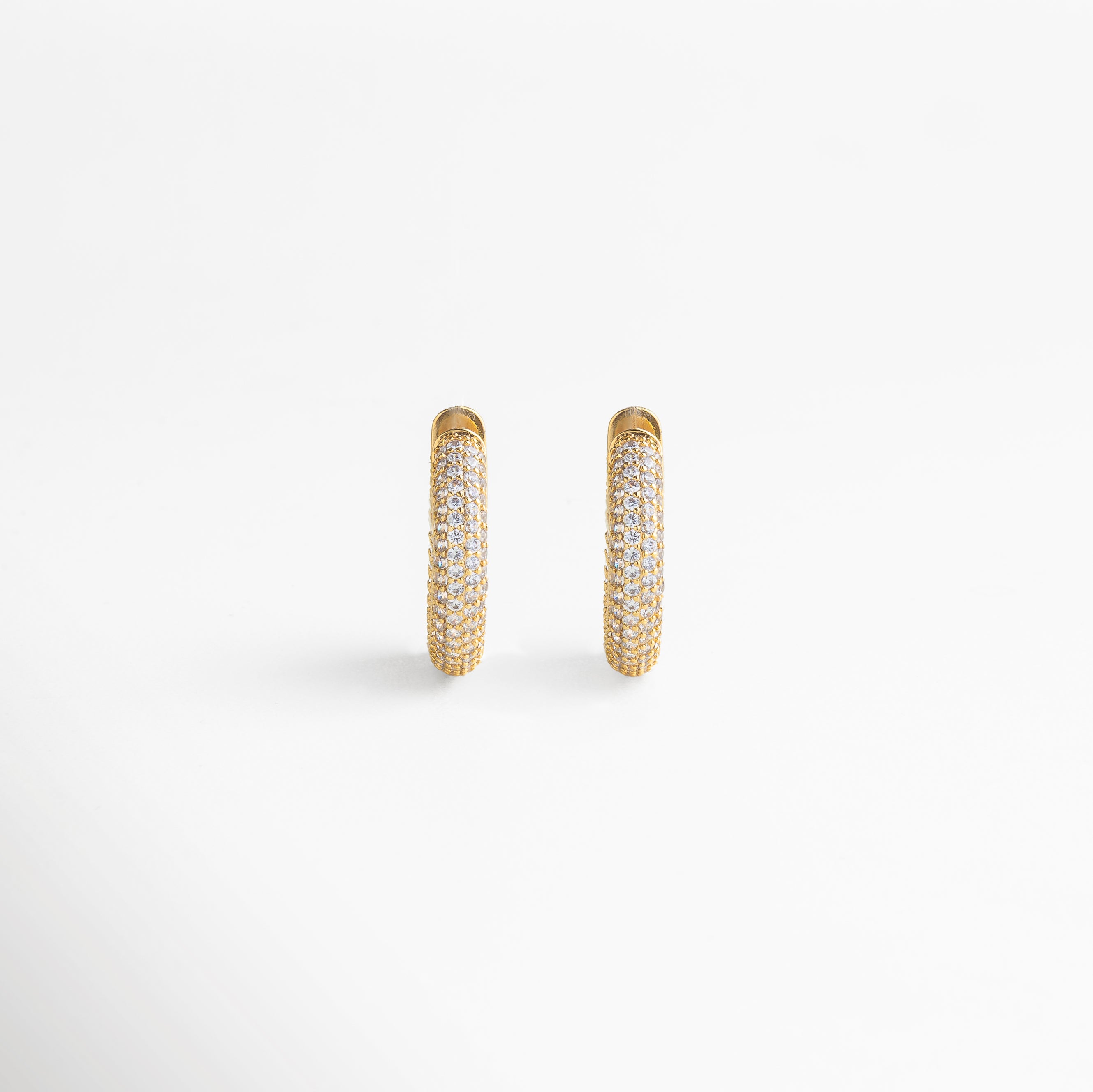 enfoque en la zirconia cúbica, corte preciso y brillo intenso, engaste cuidado que resalta cada gema, acabado dorado pulido, detalle refinado y elegante