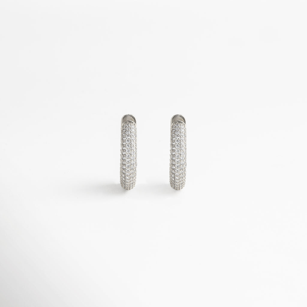 enfoque en la zirconia cúbica, corte preciso y brillo intenso, engaste cuidado que resalta cada gema, acabado en oro blanco 18K pulido, detalle refinado y elegante