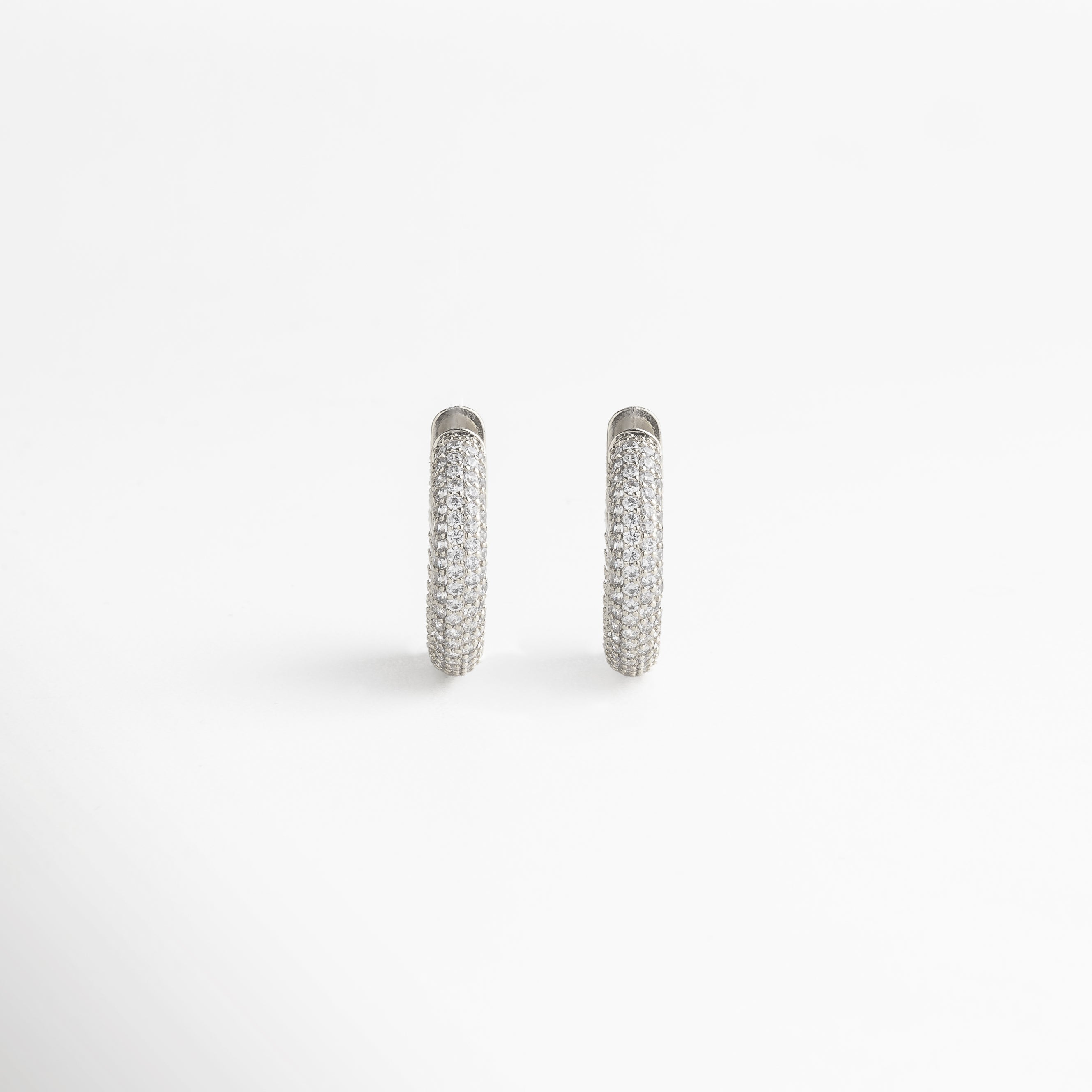 enfoque en la zirconia cúbica, corte preciso y brillo intenso, engaste cuidado que resalta cada gema, acabado en oro blanco 18K pulido, detalle refinado y elegante