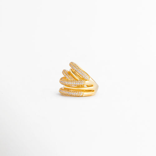 Vista lateral del anillo multicapa que resalta la superposición de bandas y el brillo de las zirconias, Perfil lateral de anillo con diseño envolvente en tonos dorado y plateado, inspirado en tendencias modernas de joyería, Anillo de múltiples aros entrelazados visto de costado, destacando su volumen y acabado premium, Detalle lateral del anillo con incrustaciones de zirconias y combinación de metales para un look sofisticado, Perspectiva lateral que muestra la estructura dinámica y elegante de este anillo 