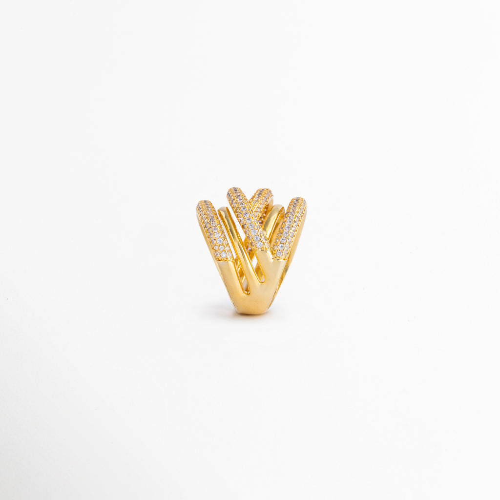 Vista superior del anillo que revela el patrón de bandas cruzadas decoradas con zirconias brillantes, Anillo de diseño arquitectónico con múltiples líneas metálicas y detalles de brillo en acabado bicolor, Detalle frontal de anillo elegante con combinación de oro 18K y rodio plateado para un efecto sofisticado, Vista superior que destaca la distribución de zirconias y la estructura envolvente del diseño, Anillo moderno con bandas entrelazadas y acabado brillante que aporta textura y dimensión.