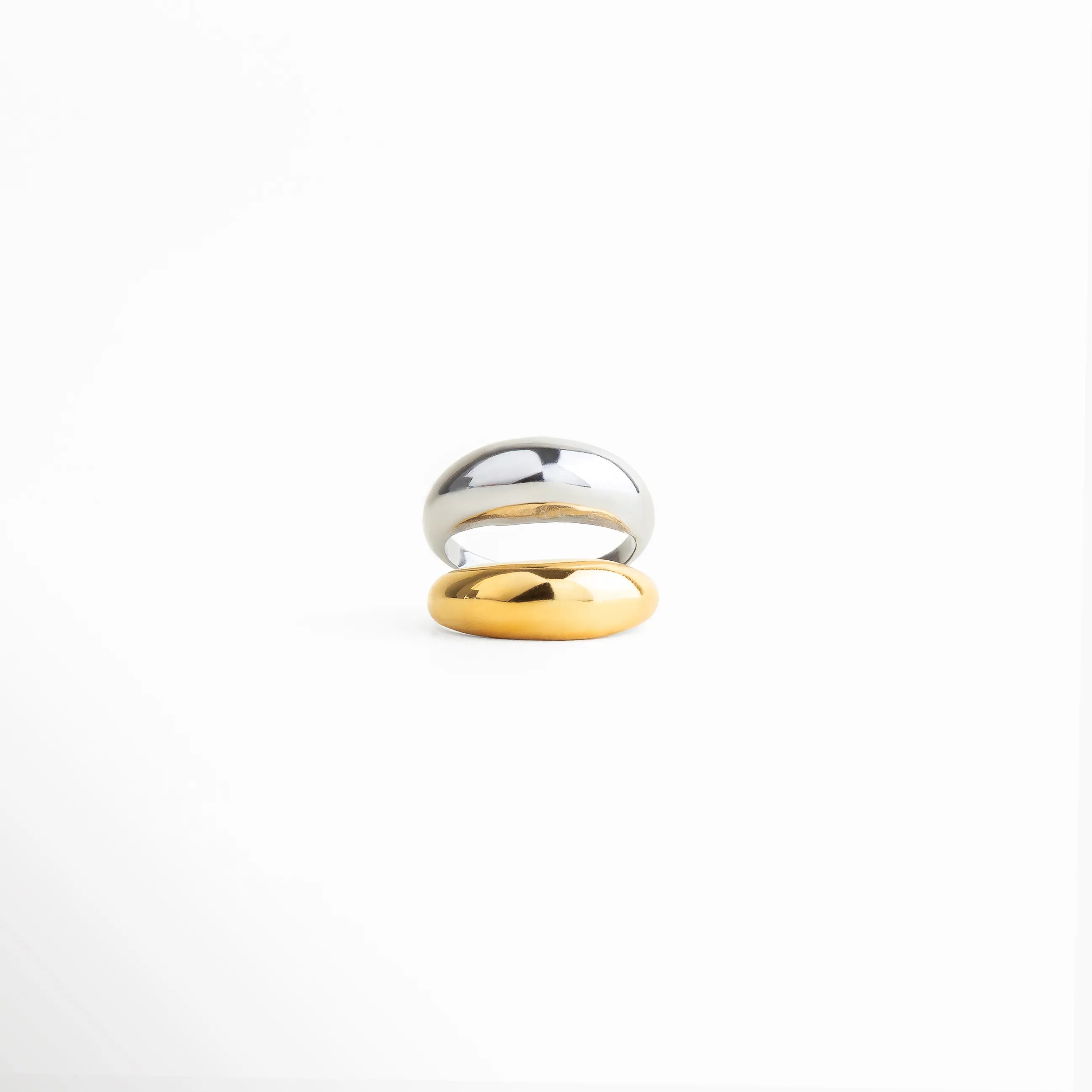 Anillo bicolor dorado y plateado con acabado pulido, diseño minimalista de líneas suaves, joyería elegante y contemporánea para mujer.