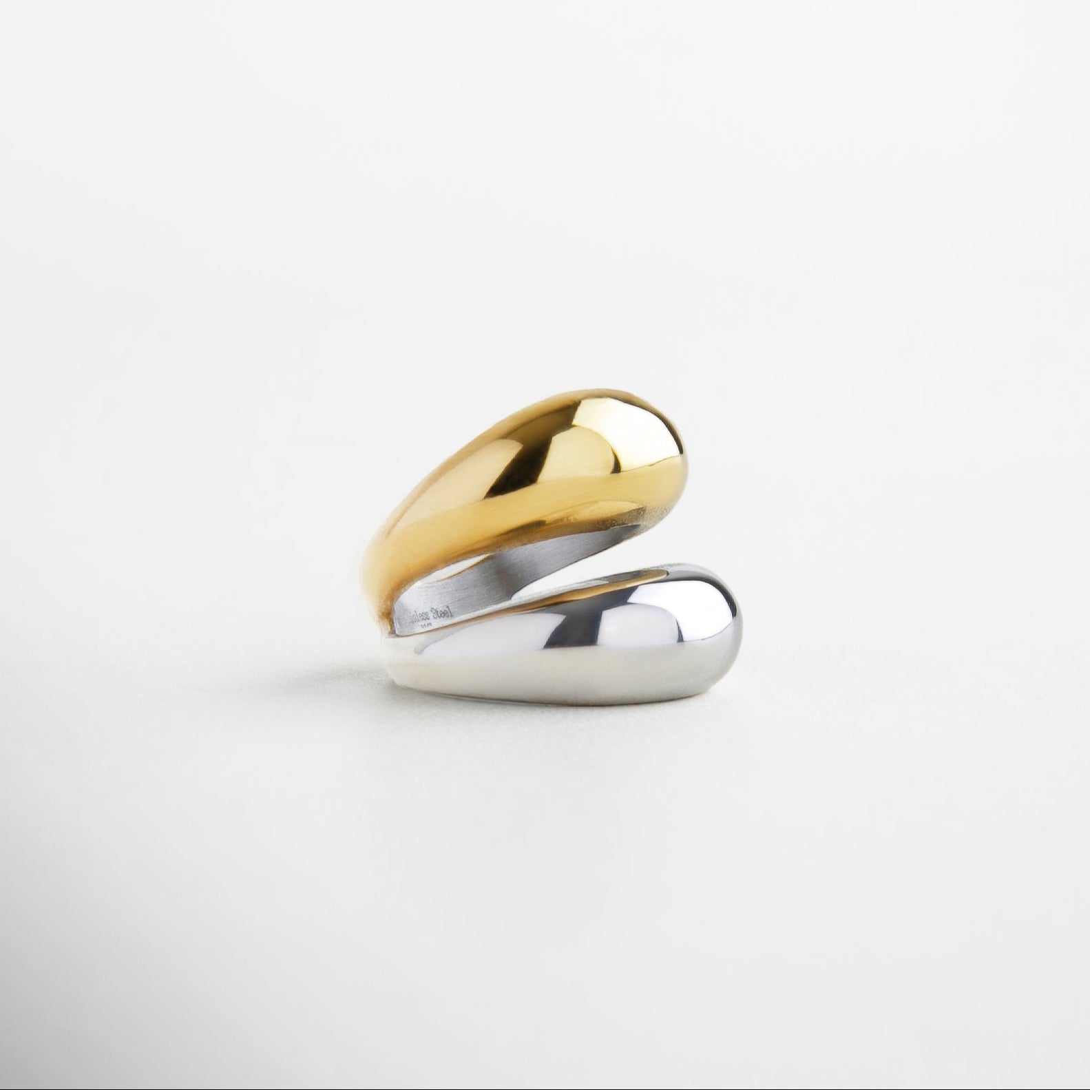 Vista lateral del anillo con doble banda contrastante, Anillo de acero inoxidable con diseño bitono moderno, Perfil audaz de anillo dorado y plateado, Diseño de bandas paralelas con acabados metálicos