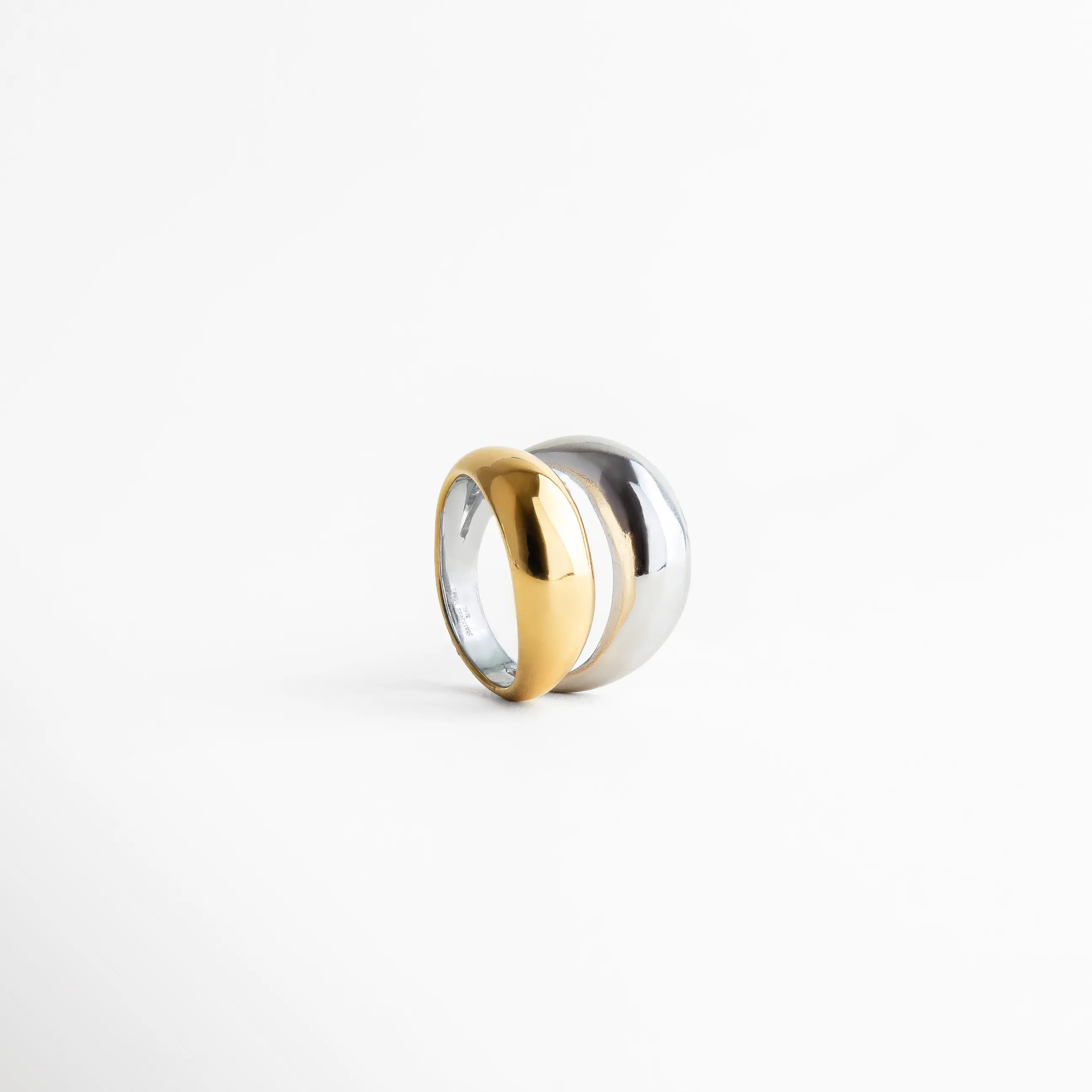Vista frontal del anillo bicolor con combinación de tonos dorado y plateado, diseño moderno de silueta limpia y estética sofisticada.