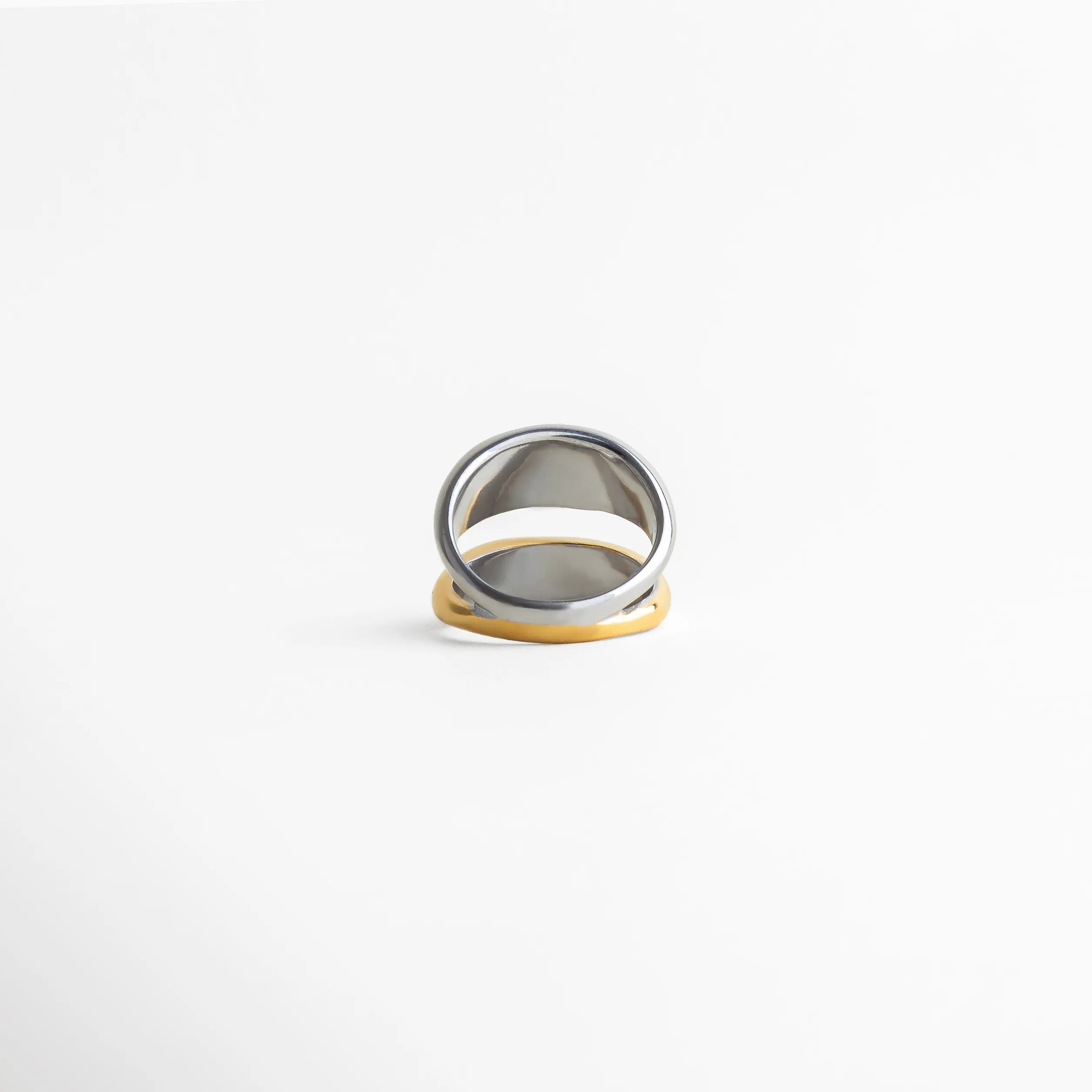 Vista lateral del anillo femenino bicolor con acabado liso y forma envolvente, joyería minimalista ideal para uso diario o layering.