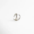 Anillo plateado abierto con acabado pulido, diseño minimalista de líneas envolventes y estética moderna, joyería elegante para mujer.