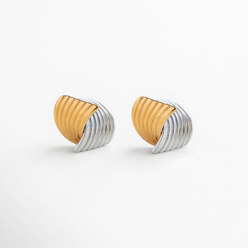 Detalle de diseño entrelazado en aretes Ita Bitono, acero inoxidable 316 con acabado mixto en oro 18K y oro blanco 18K texturizado, contraste elegante entre dorado cálido y plateado brillante, joyería moderna y refinada