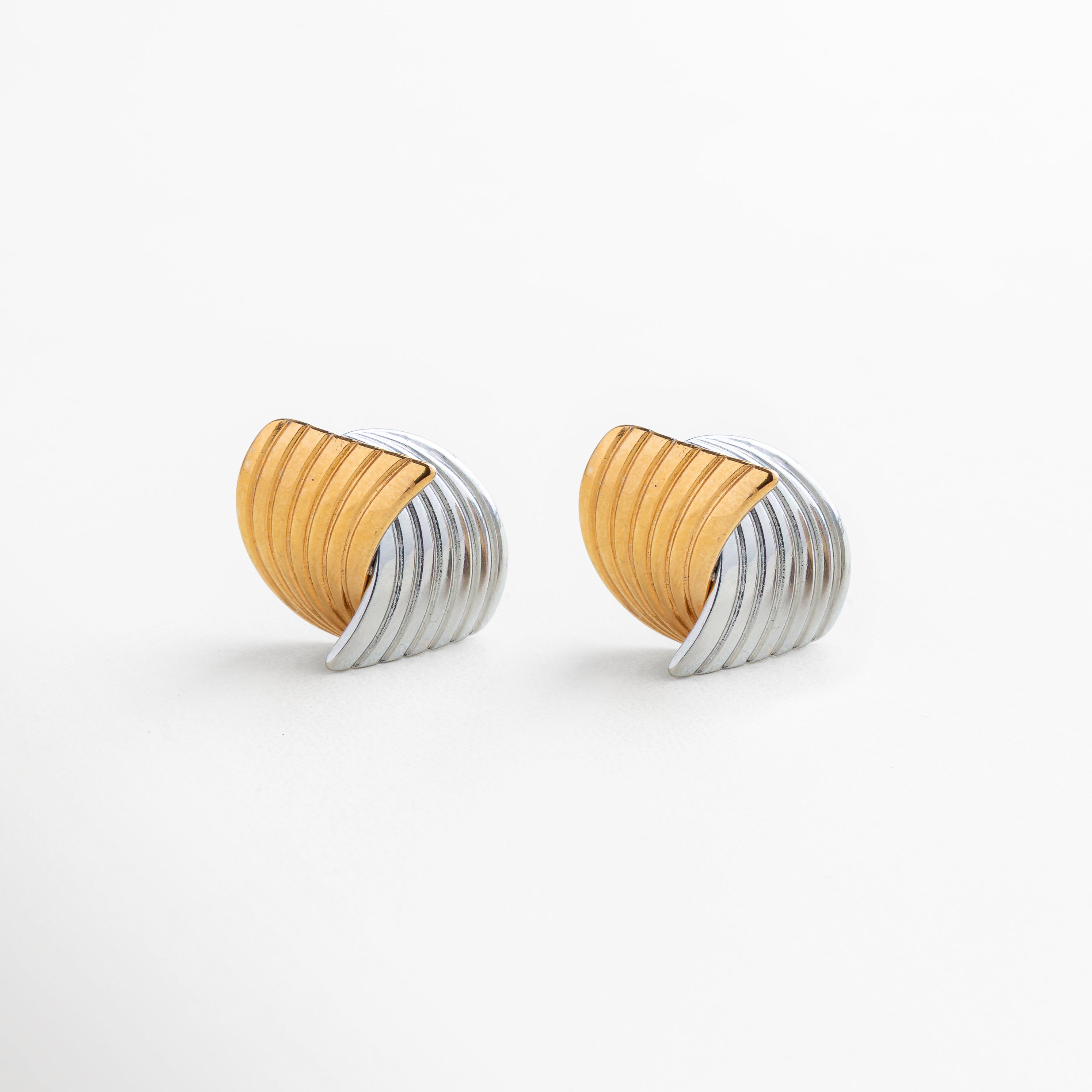 Detalle de diseño entrelazado en aretes Ita Bitono, acero inoxidable 316 con acabado mixto en oro 18K y oro blanco 18K texturizado, contraste elegante entre dorado cálido y plateado brillante, joyería moderna y refinada
