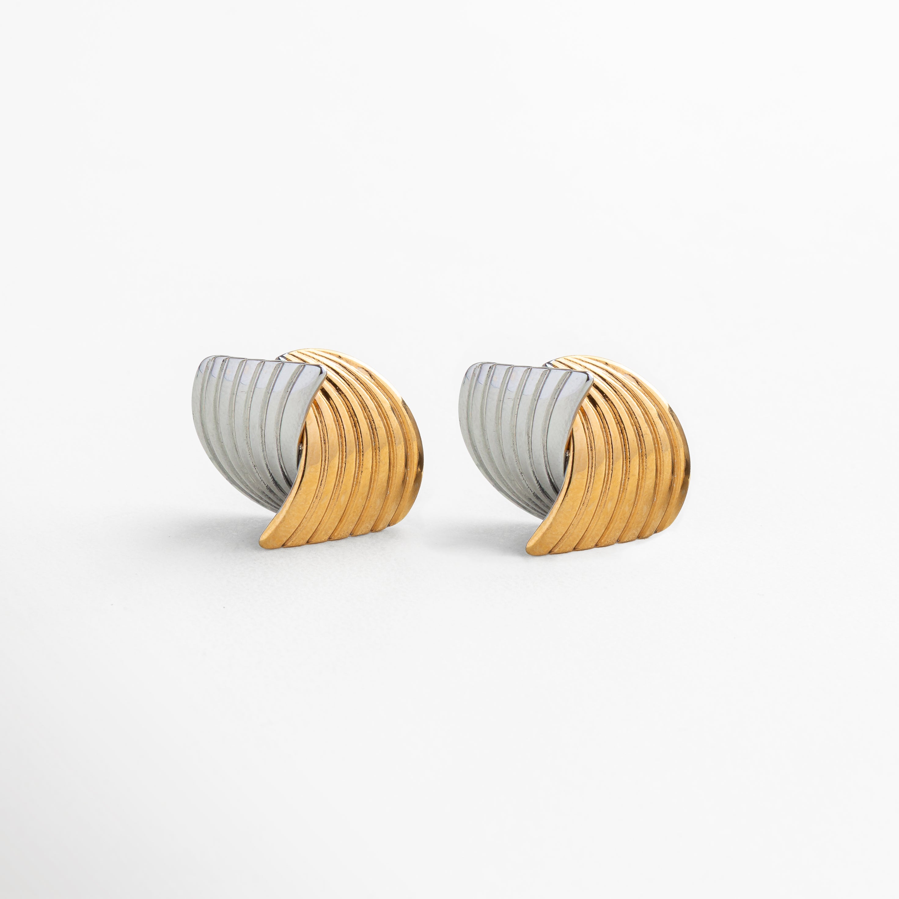Primer plano del acabado texturizado y contraste de color en aretes Ita Bitono, fabricados en acero inoxidable 316, diseño artístico y contemporáneo que refleja la luz con un toque sofisticado