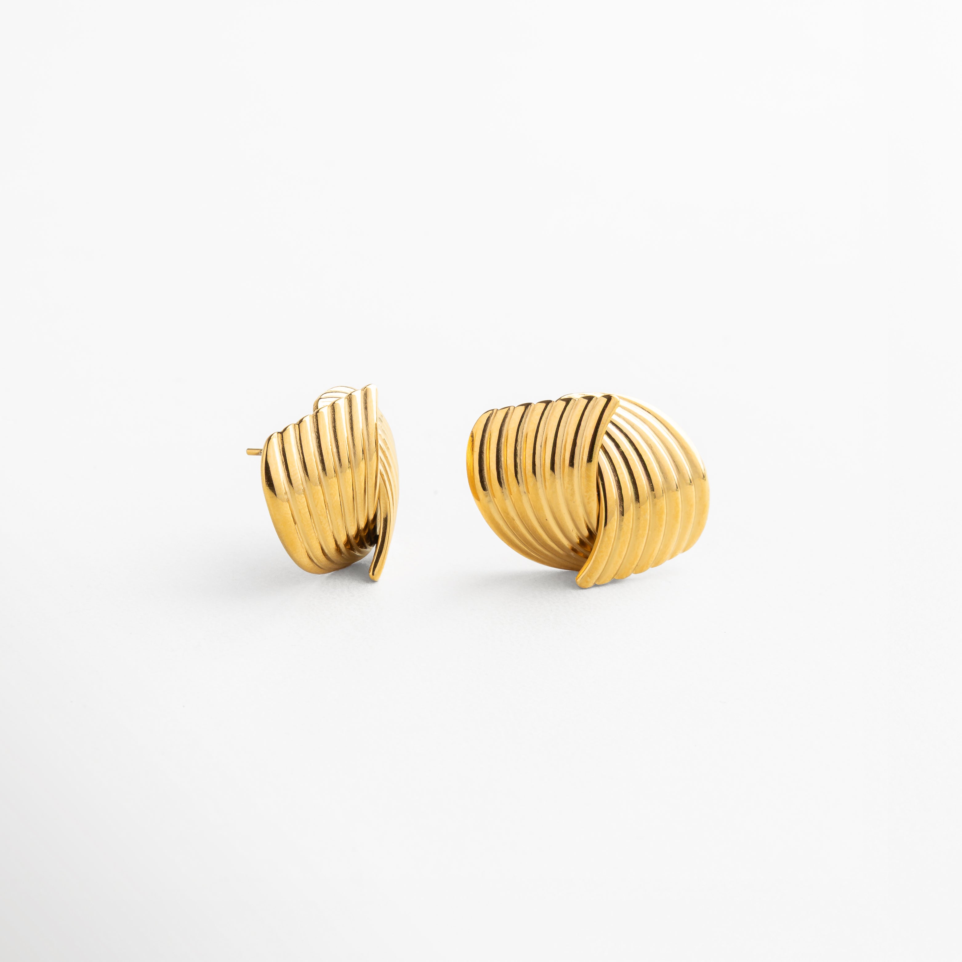 Detalle del diseño entrelazado en aretes Ita Golden de acero inoxidable 316, acabado en oro 18K brillante, estilo minimalista con carácter, juego de luces en cada movimiento, piezas versátiles y modernas