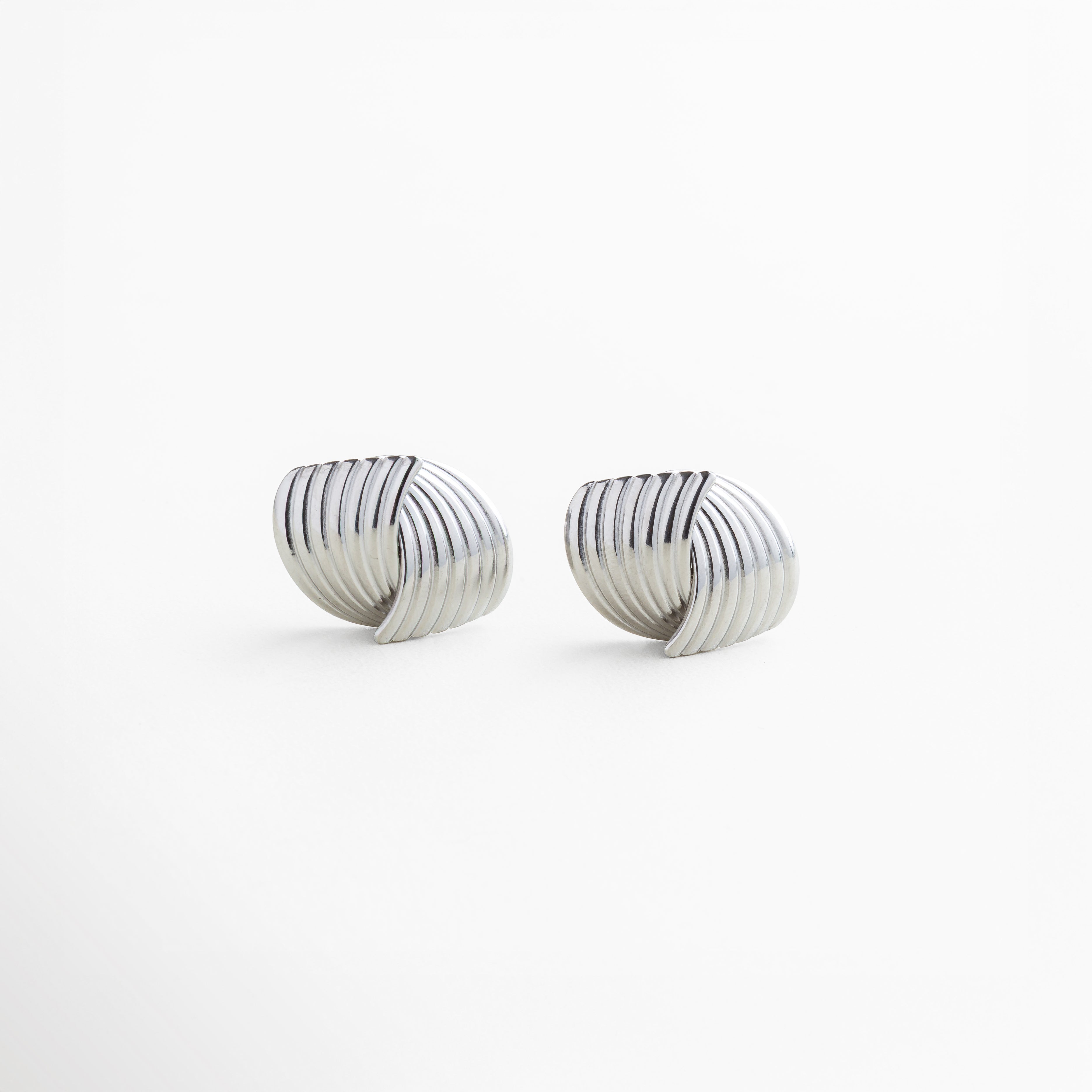 Aretes Ita Silver en acero inoxidable 316 con recubrimiento en oro blanco 18K texturizado, diseño envolvente moderno y elegante, longitud 2.5 cm y ancho 2.1 cm, joyería fina para uso diario, brillo sutil y sofisticado