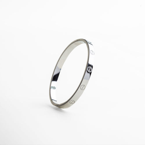 detalle del acabado pulido del brazalete plateado, superficie lisa y metálica del brazalete de titanio, bordes delgados y minimalistas en brazalete estructurado, textura brillante en acabado de oro blanco 18K, enfoque en línea limpia del diseño contemporáneo