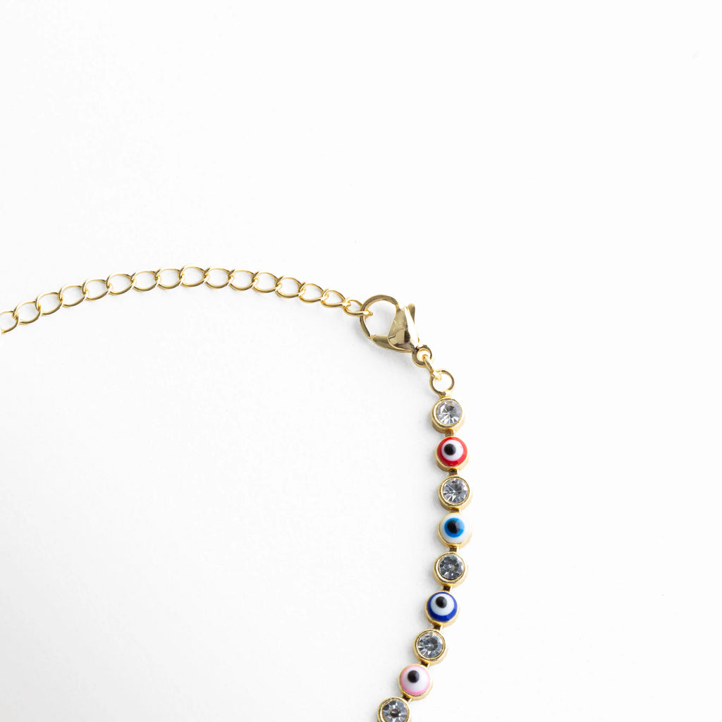 Cadena ajustable de pulsera dorada con ojitos multicolor y cierre delicado, Detalle del broche y extensión de pulsera con diseño fino y piedras de colores, Vista de la estructura de la pulsera con eslabones dorados y piedras multicolor, Pulsera ajustable con cadena dorada y ojos turcos distribuidos en colores, Segmento de pulsera con patrón continuo de ojitos multicolor y acabado brillante