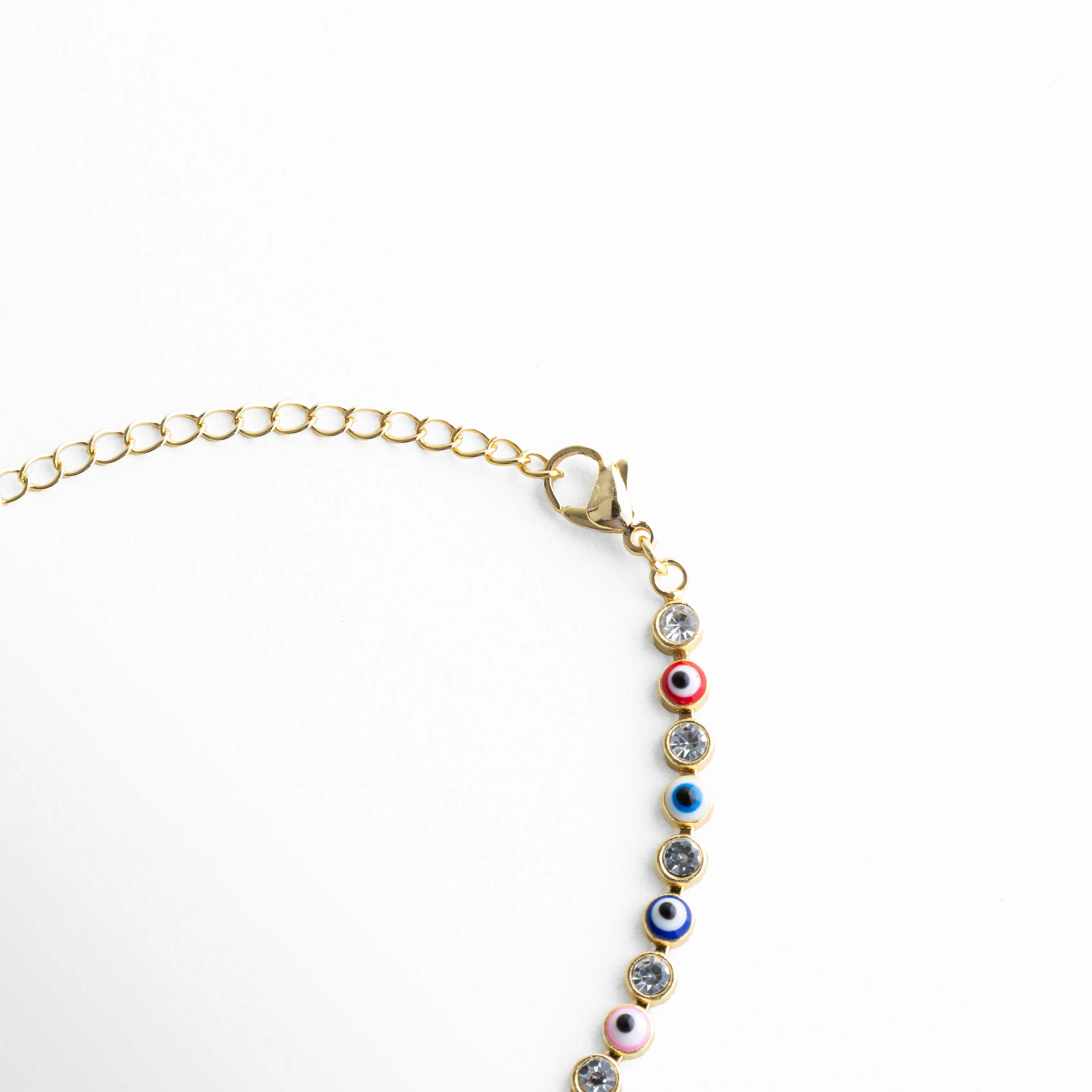Cadena ajustable de pulsera dorada con ojitos multicolor y cierre delicado, Detalle del broche y extensión de pulsera con diseño fino y piedras de colores, Vista de la estructura de la pulsera con eslabones dorados y piedras multicolor, Pulsera ajustable con cadena dorada y ojos turcos distribuidos en colores, Segmento de pulsera con patrón continuo de ojitos multicolor y acabado brillante