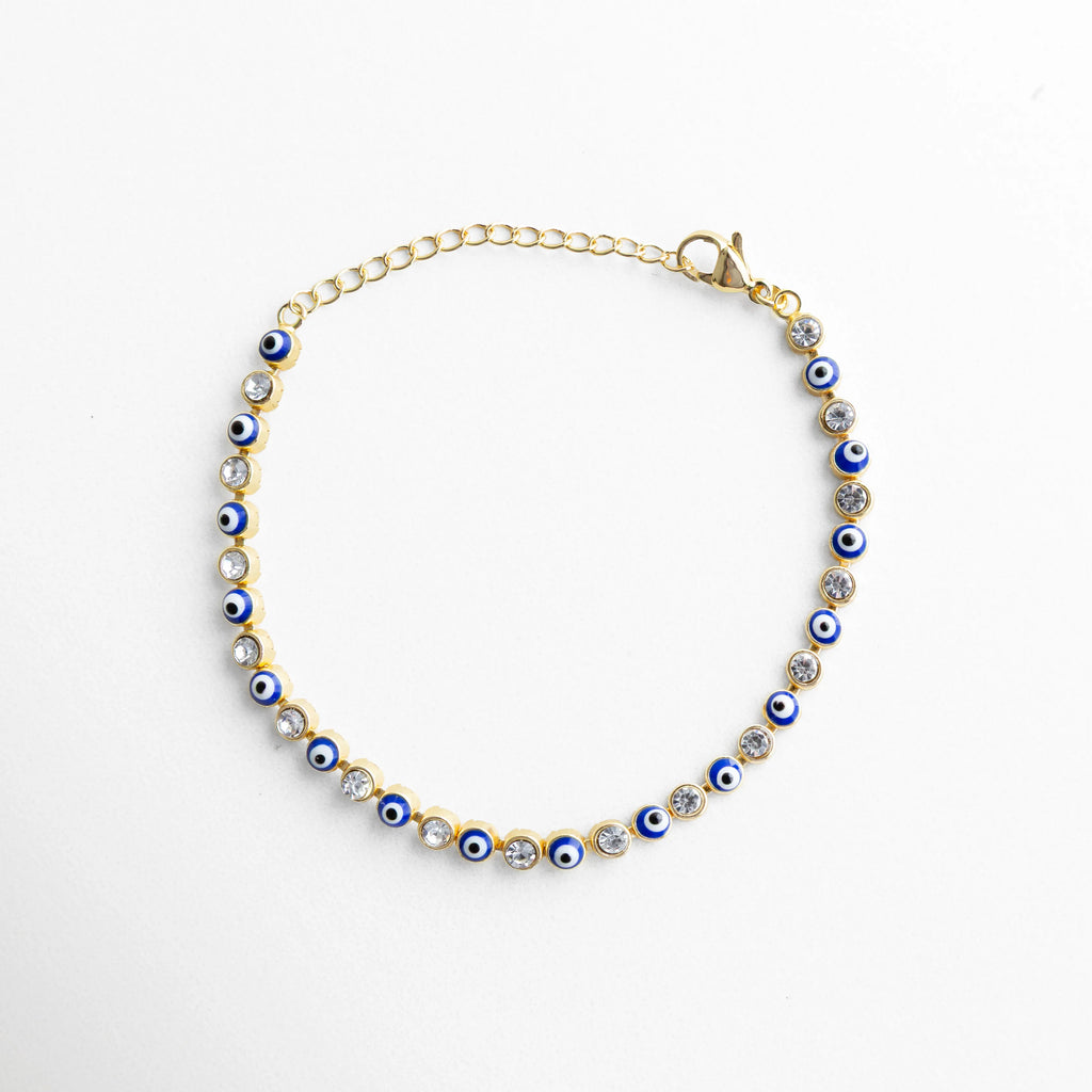 Pulsera ojitos azul dorada con piedras brillantes y diseño de ojo turco elegante, Pulsera de ojo turco azul con zirconias enchapada en oro 18K, estilo moderno y protector, Pulsera fina dorada con ojitos azules y piedras brillantes, accesorio delicado mujer, Pulsera ojitos azul con acabado dorado y diseño continuo, joyería elegante y mística, Pulsera de protección con ojos turcos azules y detalles brillantes en tono dorado