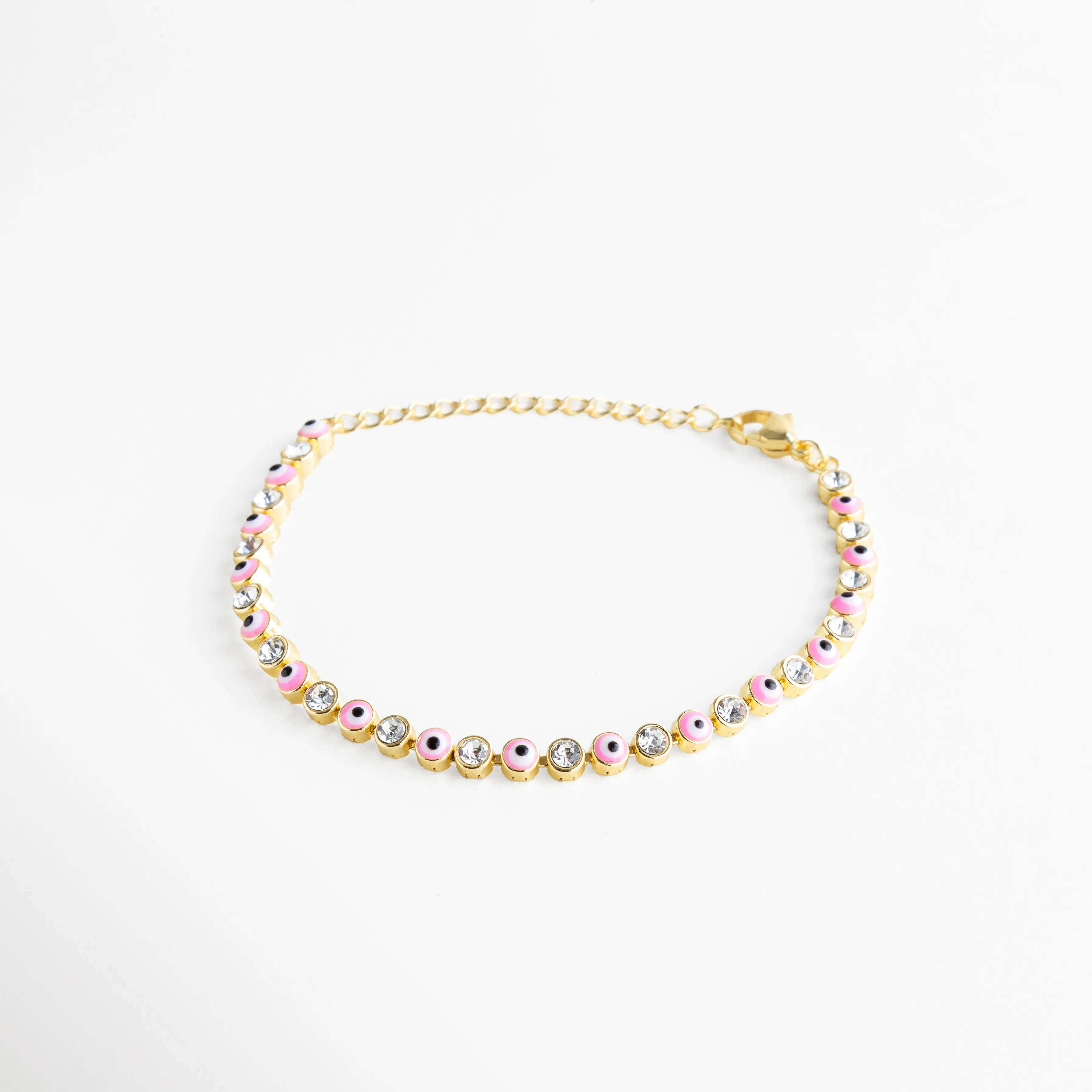 Diseño equilibrado entre brillo y color con dijes de ojo turco rosa y zirconias brillantes en acabado dorado.