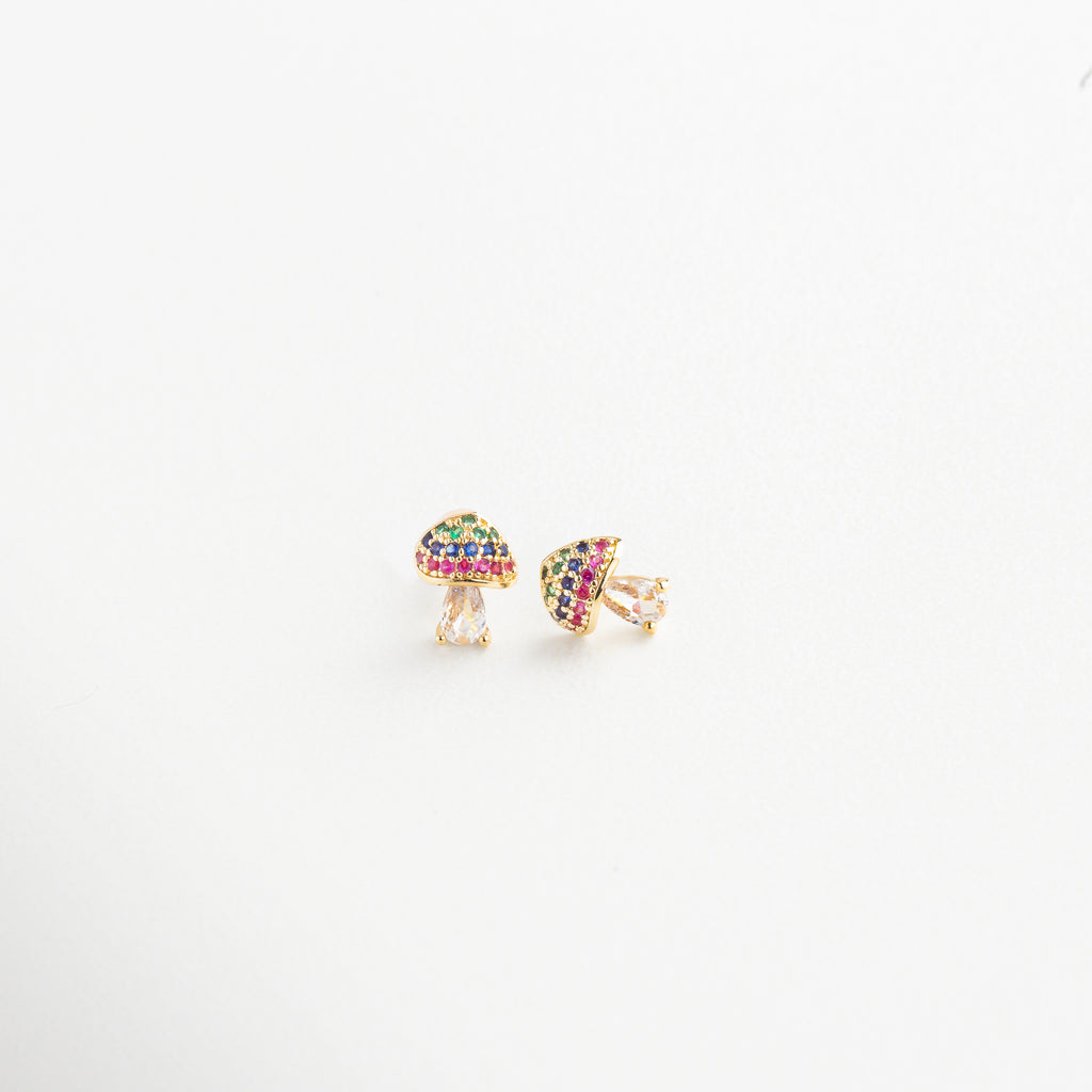 Detalle del diseño de hongo dorado con piedras coloridas, Primer plano de aretes con forma de seta y brillo multicolor, Textura y acabado dorado de pendientes con zirconias, Close-up de los aretes con diseño natural y vibrante